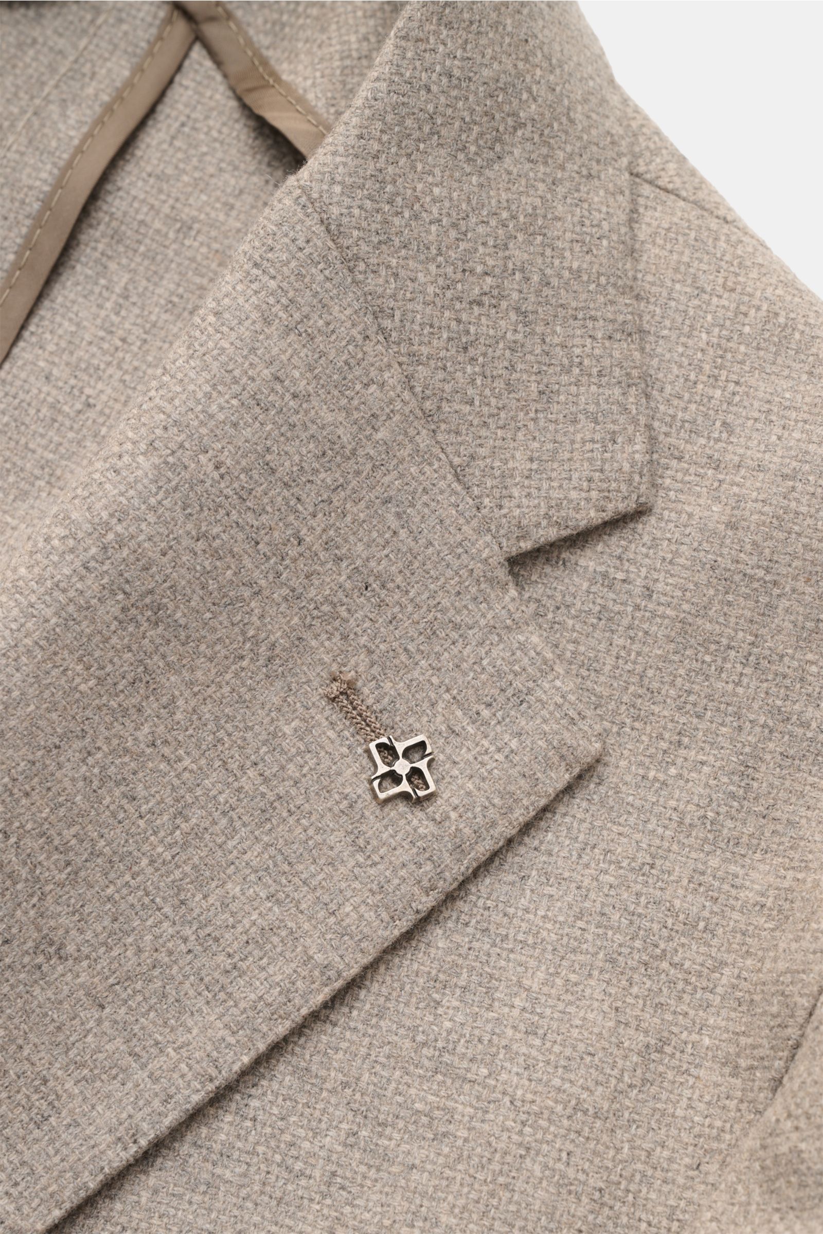 Nahaufnahme des Tagliatore Sakkos 'Monte Carlo' taupe meliert, Slim Fit mit Unconstructed-Verarbeitung aus Wolle und Cashmere, feinem Strukturgewebe, fallendem Revers und markentypischem Pin, fotografiert aus schräger Perspektive.