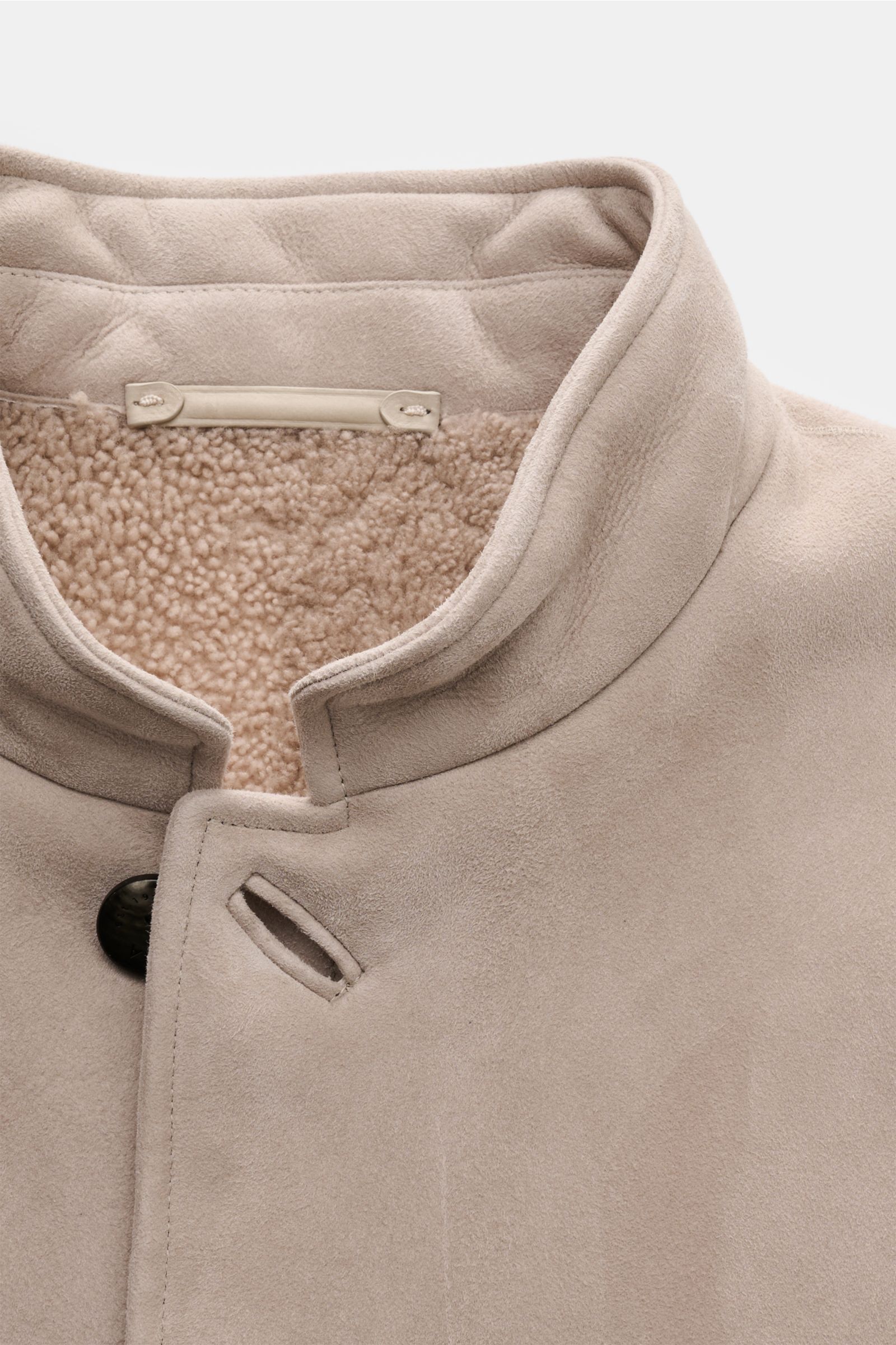 Nahaufnahme der Agnona Lammfelljacke sand im Sakko-Stil, zeigt Stehkragen, weiches Lammleder außen und Lammfellfutter innen.