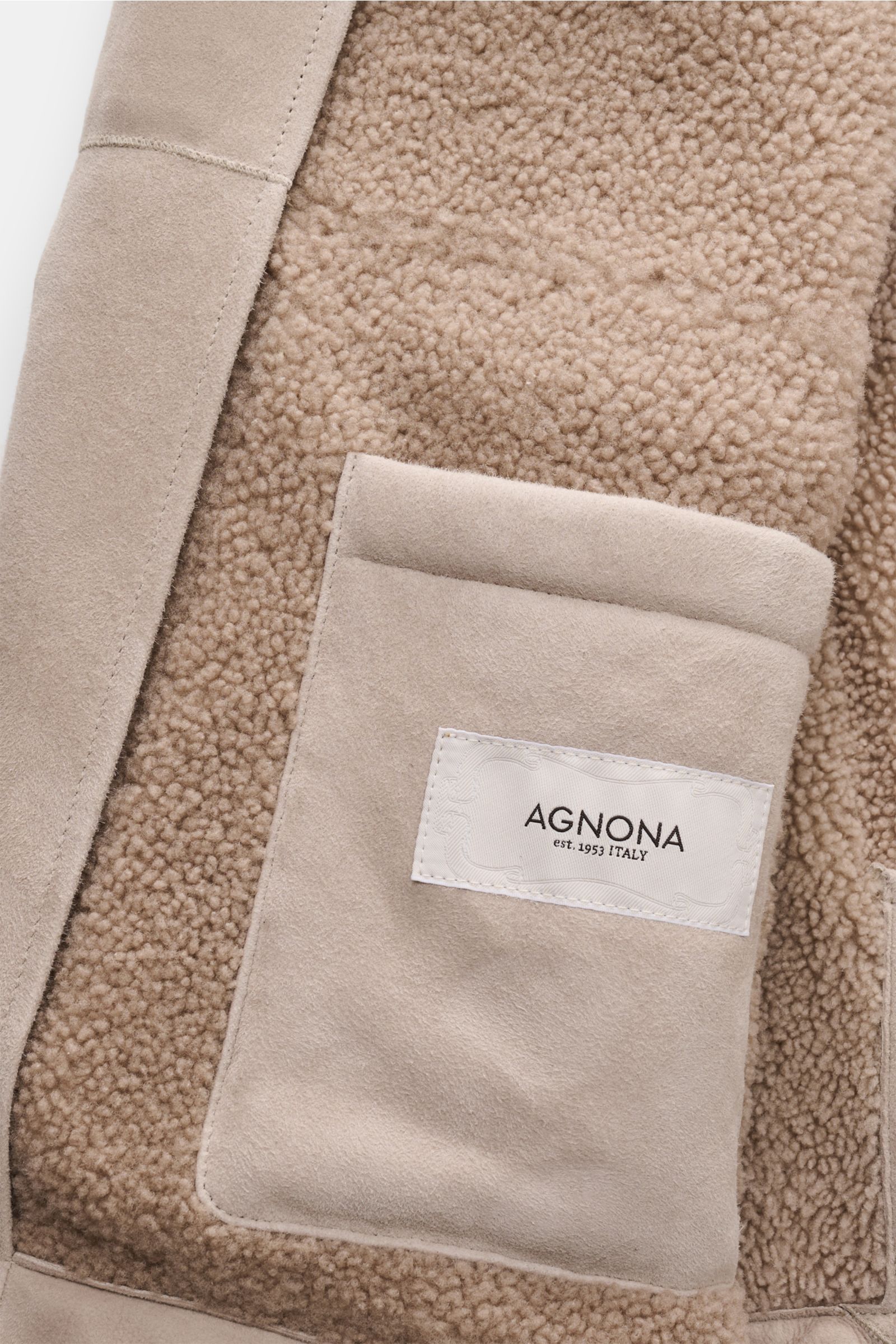 Nahaufnahme der Innenseite der Agnona Lammfelljacke sand, zeigt weiches, edles Lammleder, Lammfellfutter und eine Tasche mit Agnona-Label.