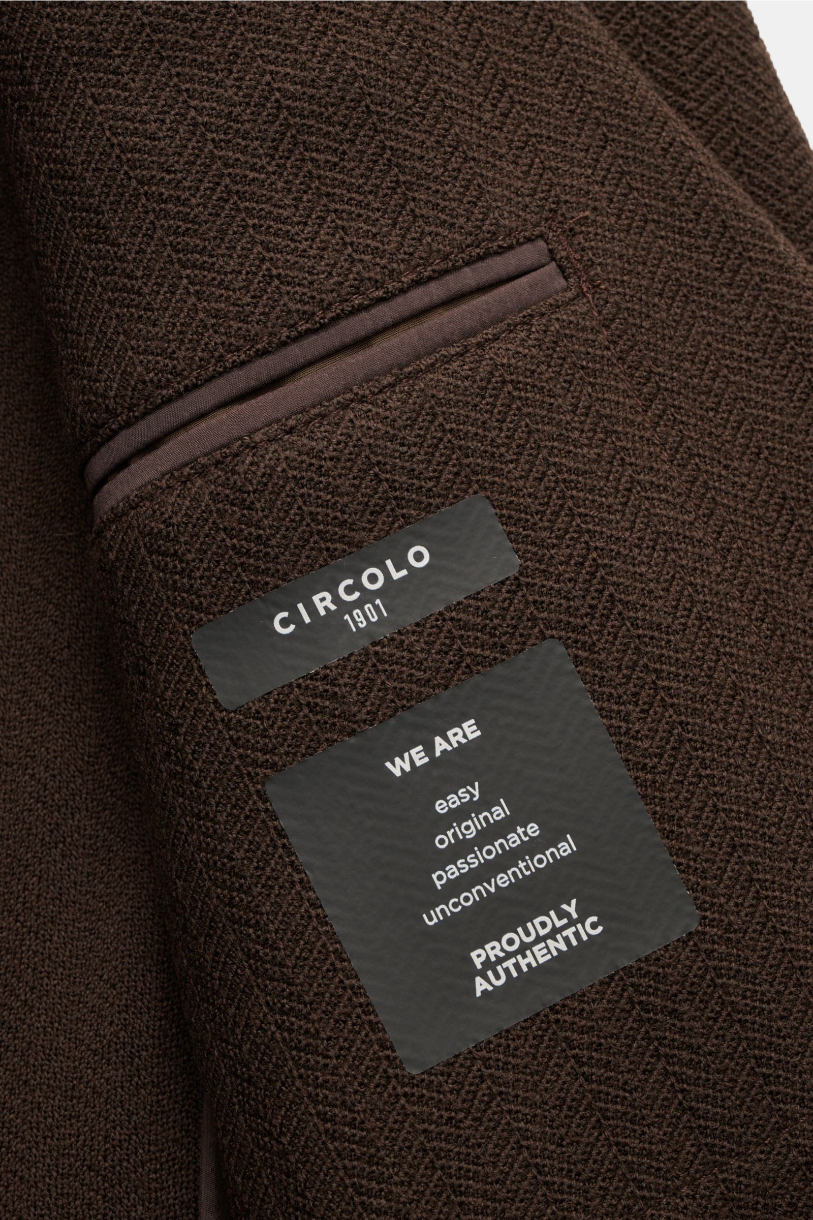 Circolo 1901 Strickblazer dunkelbraun aus reiner Wolle mit tonalem Fischgrat, weichem Griff, Slim Fit, Zwei-Knopf-Stil, fallendem Revers, Brust- und Hüfttaschen, Knopfärmeln, Seitenschlitzen, Unconstructed-Design, Innentasche, Nahaufnahme innenliegend.