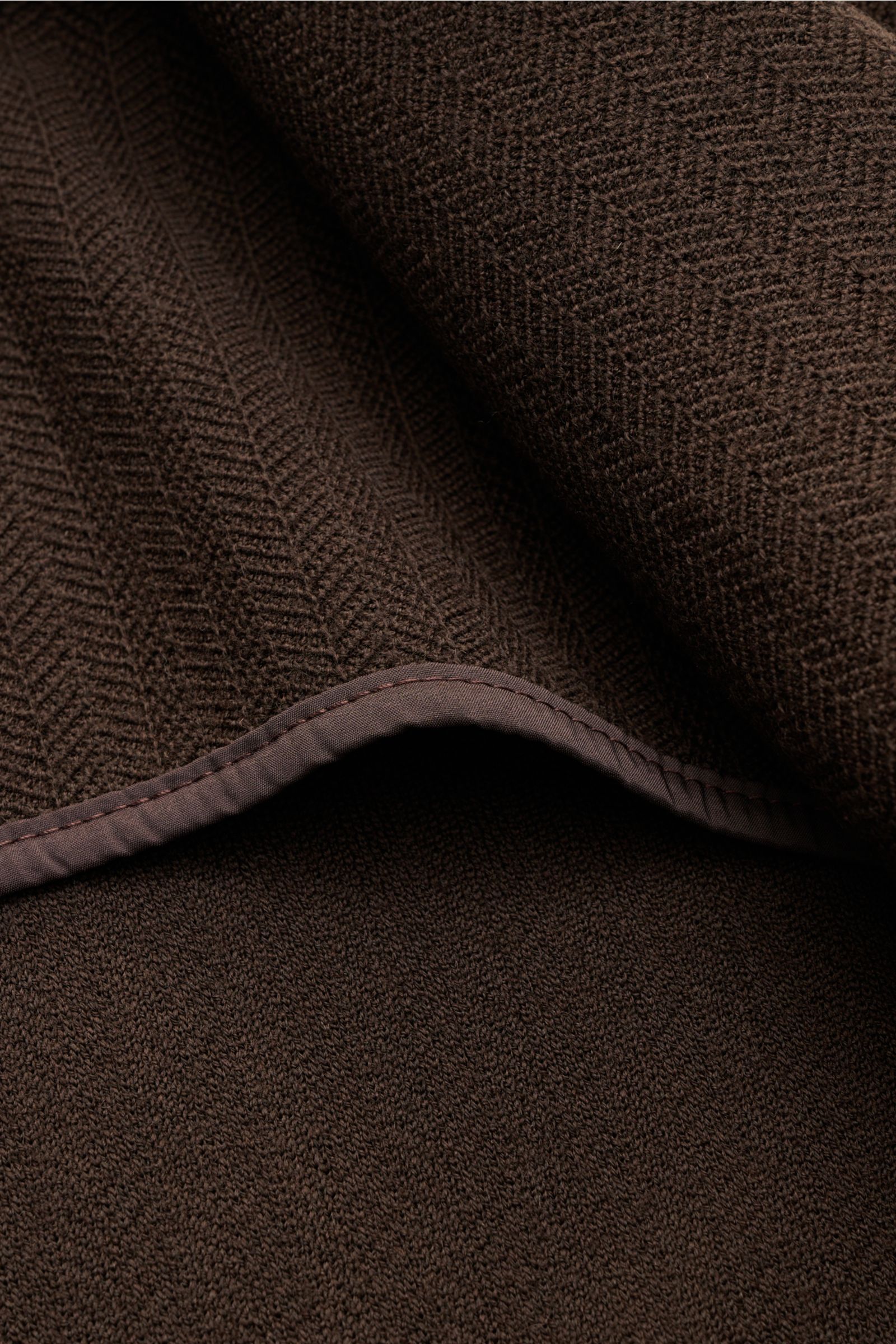 Nahaufnahme des tonalen Fischgrat-Stricks aus reiner Wolle vom Circolo 1901 Strickblazer dunkelbraun mit weichem Griff.