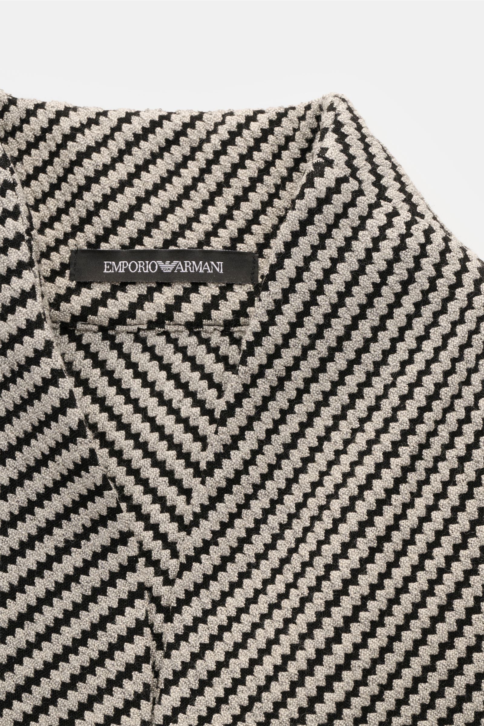 Close-up top view of Emporio Armani Sakko hellgrau/schwarz gemustert with a slim shawl collar and textured black and light grey pattern.

Description: Stilvoll durch den Frühling: Das Sakko von EMPORIO ARMANI verbindet zeitloses Design mit leichter Mat