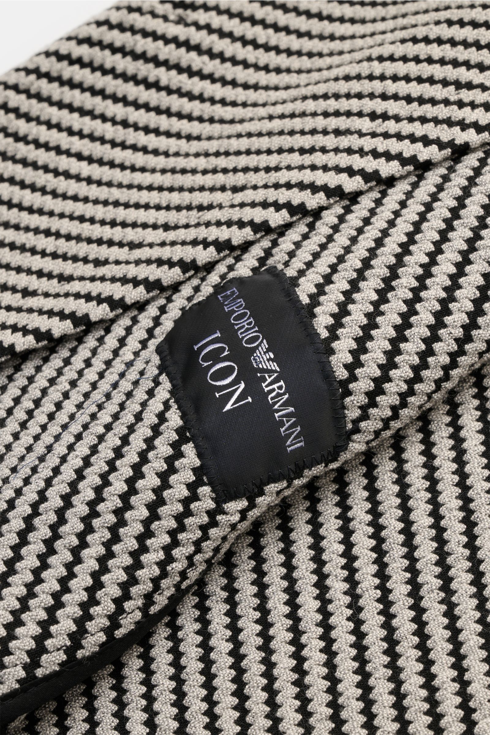 Close-up of the fabric and label of the Emporio Armani Sakko hellgrau/schwarz gemustert, showing its textured pattern and black Emporio Armani ICON tag.

Stilvoll durch den Frühling: Das Sakko von EMPORIO ARMANI verbindet zeitloses Design mit leichter 