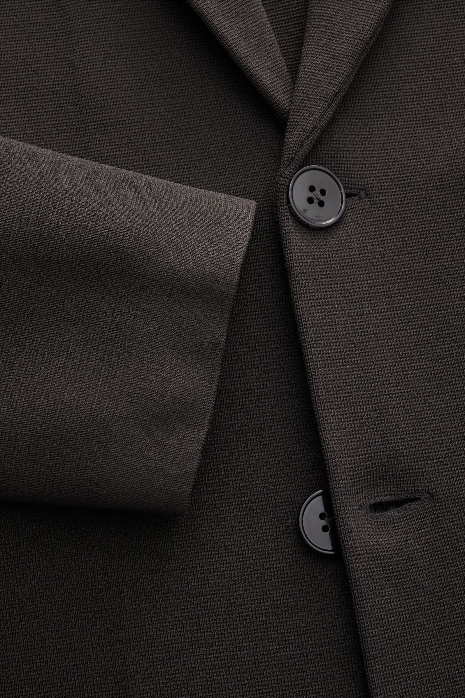 Nahaufnahme des Emporio Armani Strickblazer 'Icon' anthrazit aus nachhaltiger Viskose, Jersey mit Slim Fit, Zwei-Knopf-Stil, fallendem Revers, aufgesetzten Hüfttaschen und Unconstructed Design, fotografiert von schräger Frontperspektive.