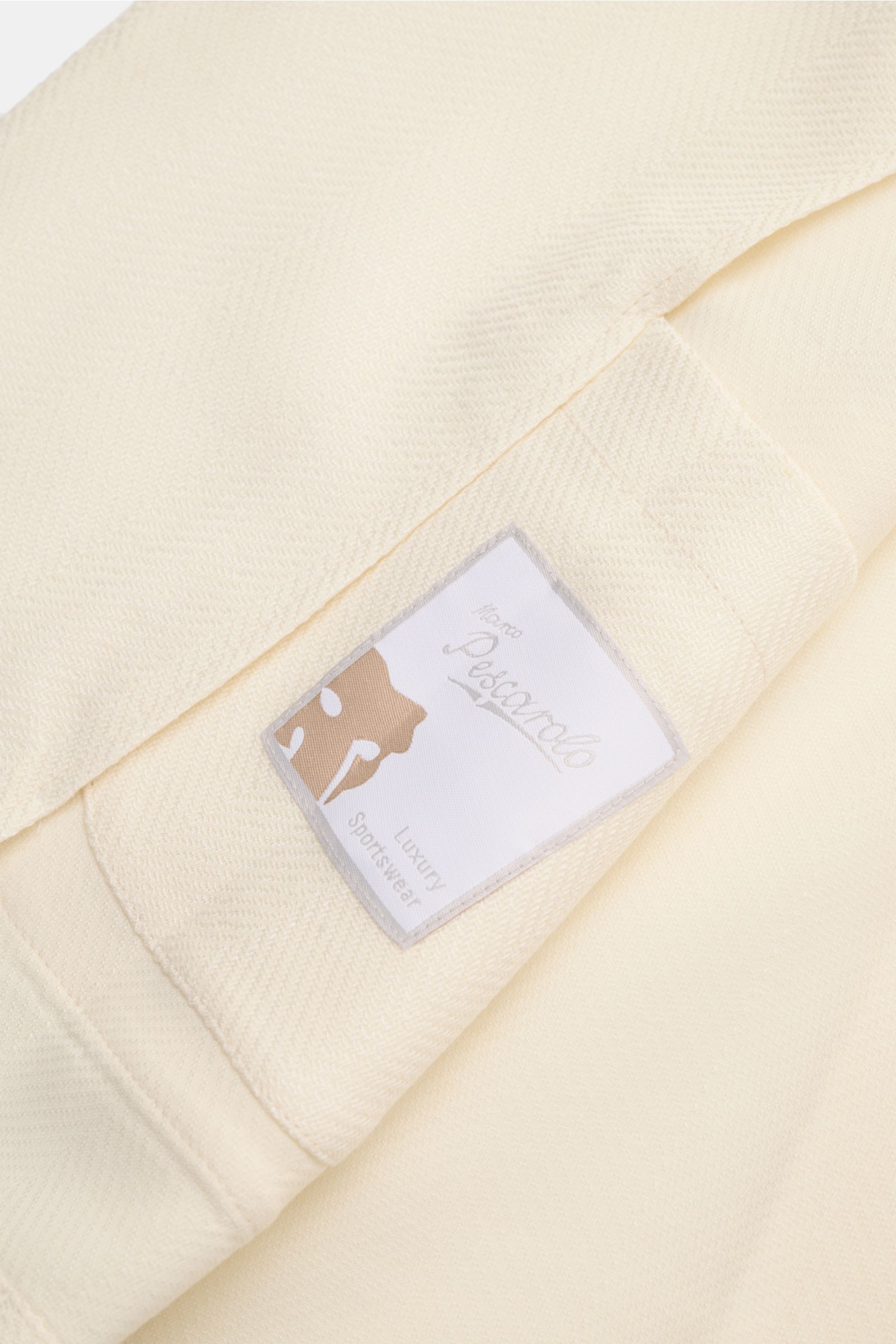 Close-up of the Marco Pescarolo Blazer 'Giove' cream label on lightweight wool-cashmere fabric, photographed from above.

Lightweight blazer with maximum comfort: MARCO PESCAROLO designs not just elegant trousers but also blazers to go with them, like 