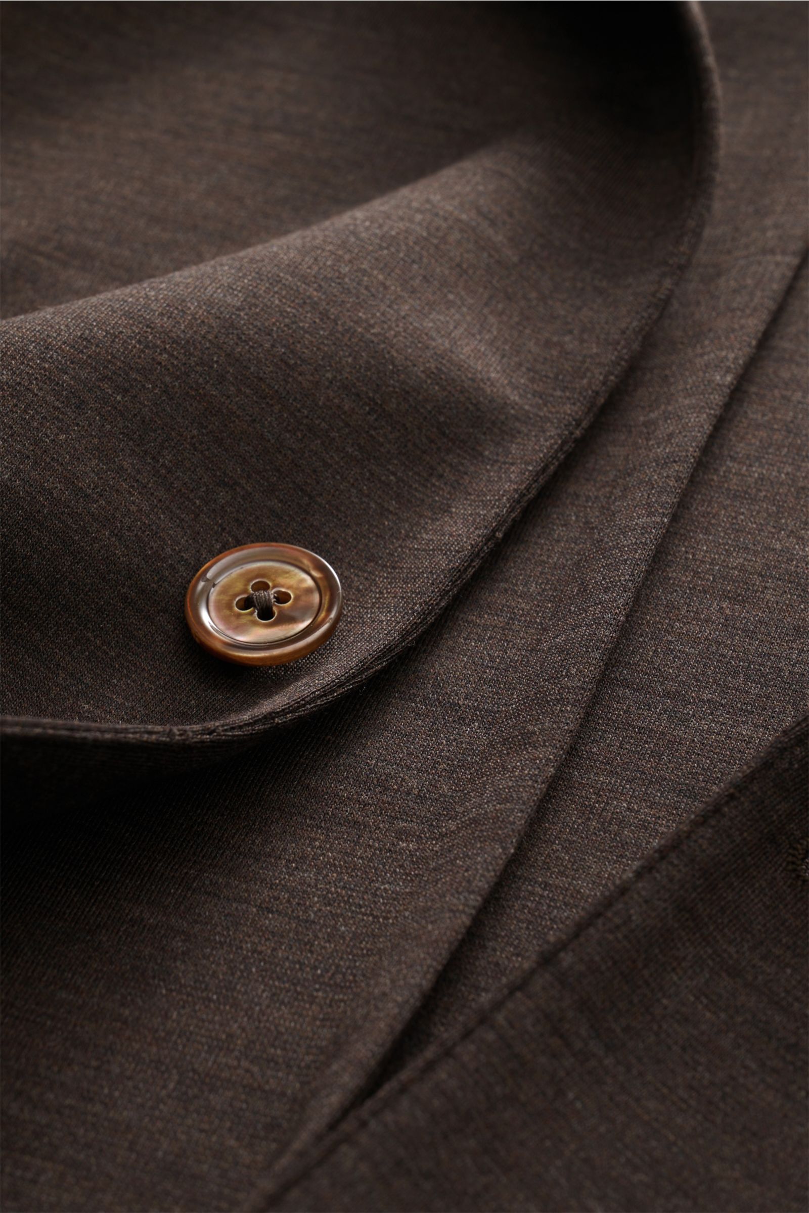Close-up front view of the Marco Pescarolo Blazer 'Giove' dunkelbraun meliert showing fine wool jersey fabric and a brown button.

Description: Leichter Blazer mit höchstem Tragekomfort: MARCO PESCAROLO designt nicht nur edle Hosen, sondern auch Blazer