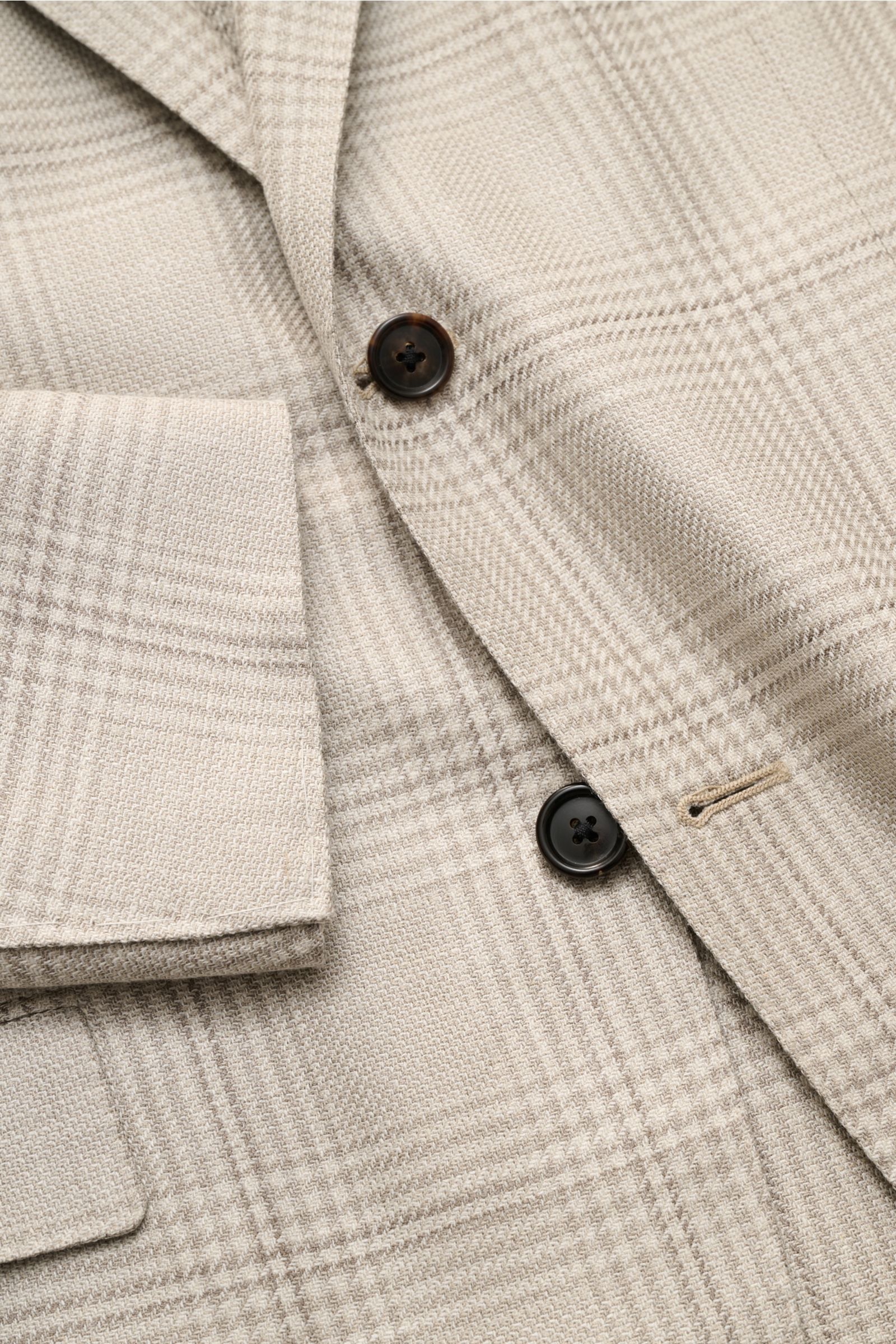 Close-up front view of the Corneliani Smart-casual jacket light grey/cream checked showing buttons, lapel, and pocket details.

Stylish and uncomplicated – with its comfortably lightweight blend of wool, silk and linen and its high-quality details, thi