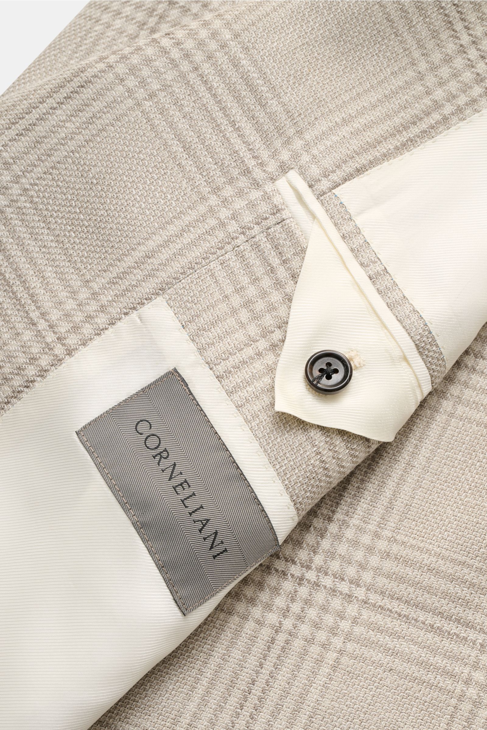 Close-up top view of Corneliani Smart-casual jacket light grey/cream checked fabric, showing blend texture and inner lining with button.

Stylish and uncomplicated – with its comfortably lightweight blend of wool, silk and linen and its high-quality de
