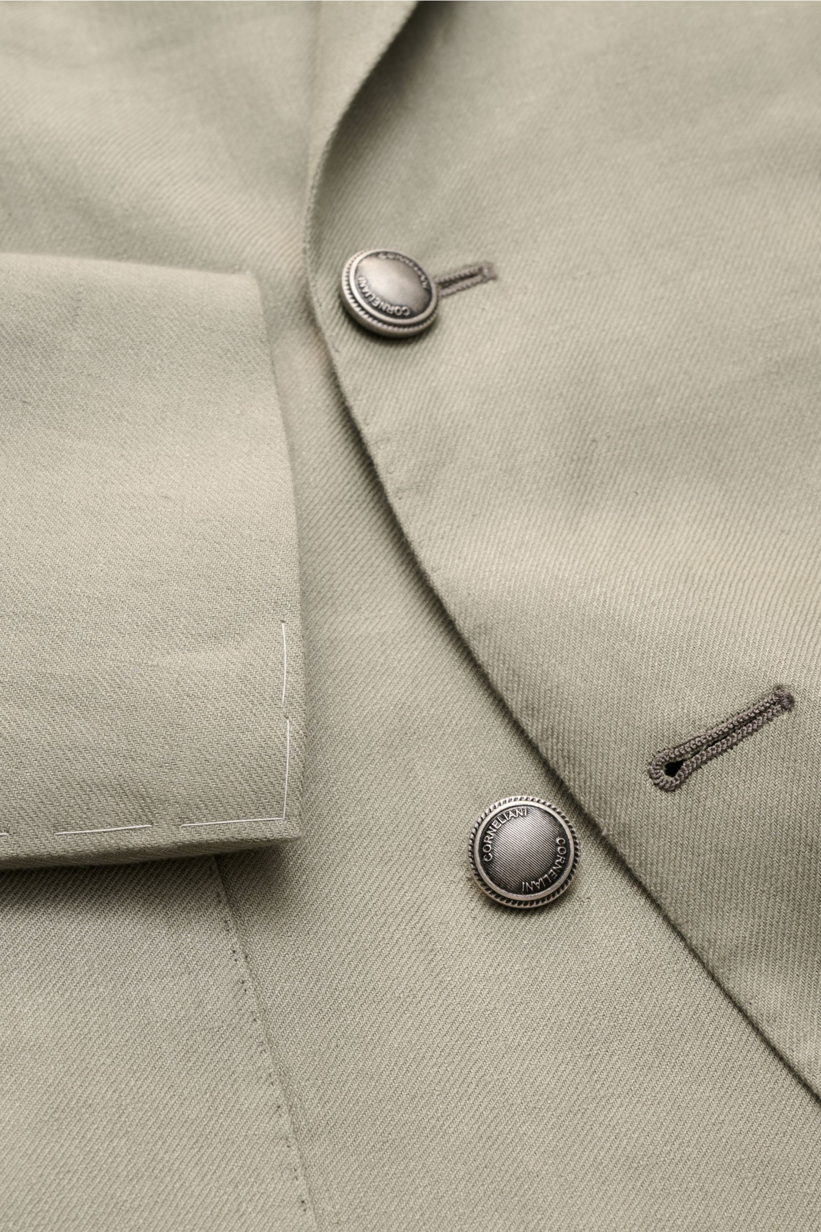 Corneliani Leinensakko salbei in Slim Fit, zweireihig, weiches Leinen mit feiner Webstruktur, Detailaufnahme von Knöpfen und Ärmel.