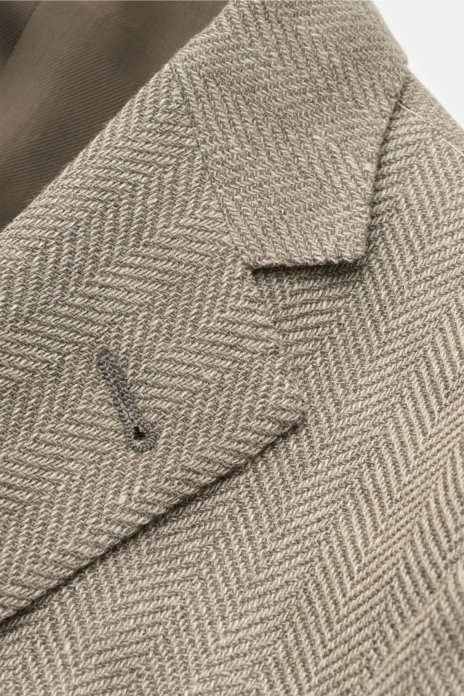 Corneliani Sakko taupe gemustert close-up from above showing herringbone wool-linen fabric with lapel, buttonhole, and inner lining. Stilvoll durch die neue Saison: mit optimalem Fit aus italienischer Meisterhand von CORNELIANI wurde dieses Sakko aus f