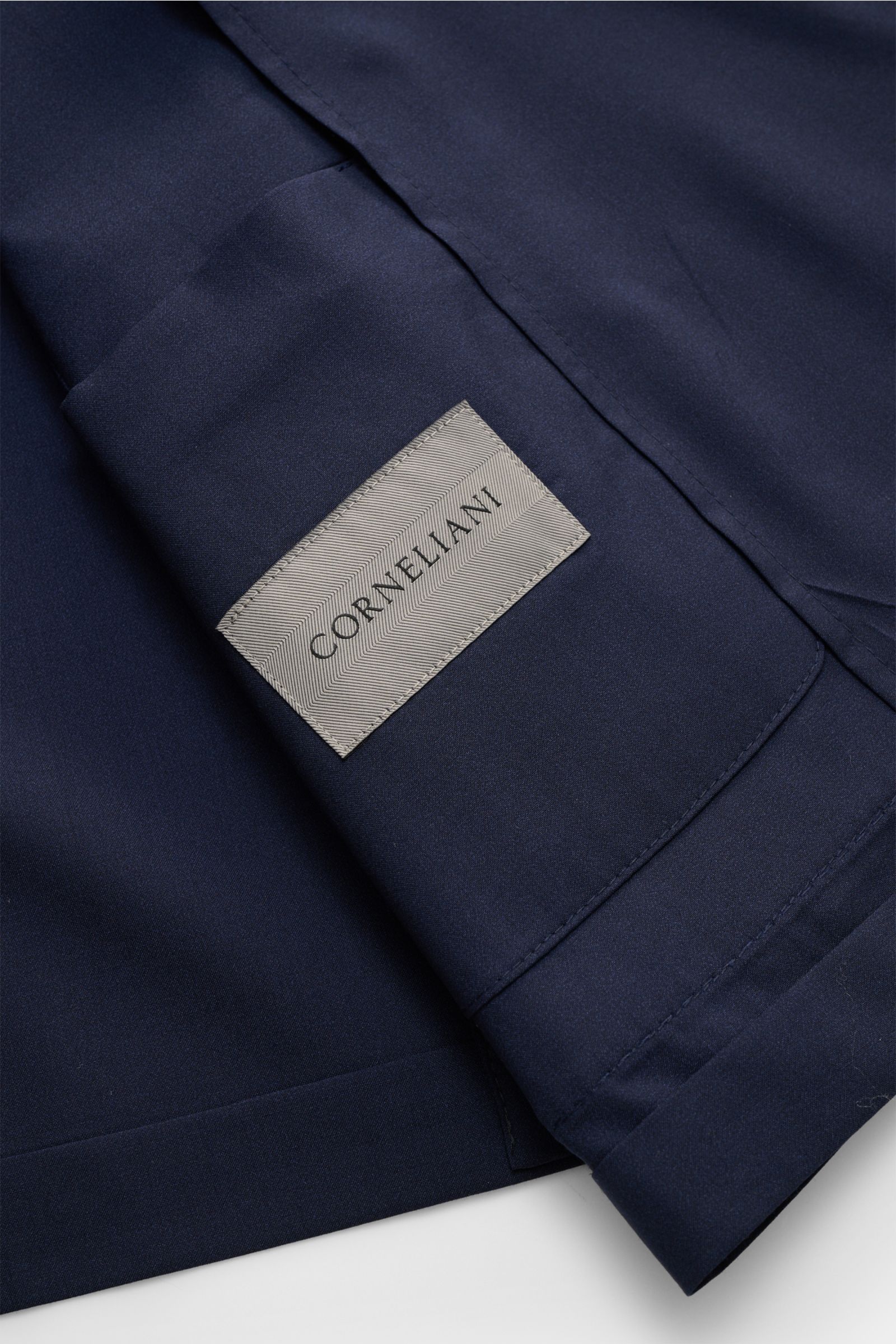 Corneliani Sakko navy aus Wolle-Seiden-Mix, glatter Griff, Slim Fit, taillierter Zwei-Knopf-Stil, Nahaufnahme von Innenetikett und Ärmelabschluss.