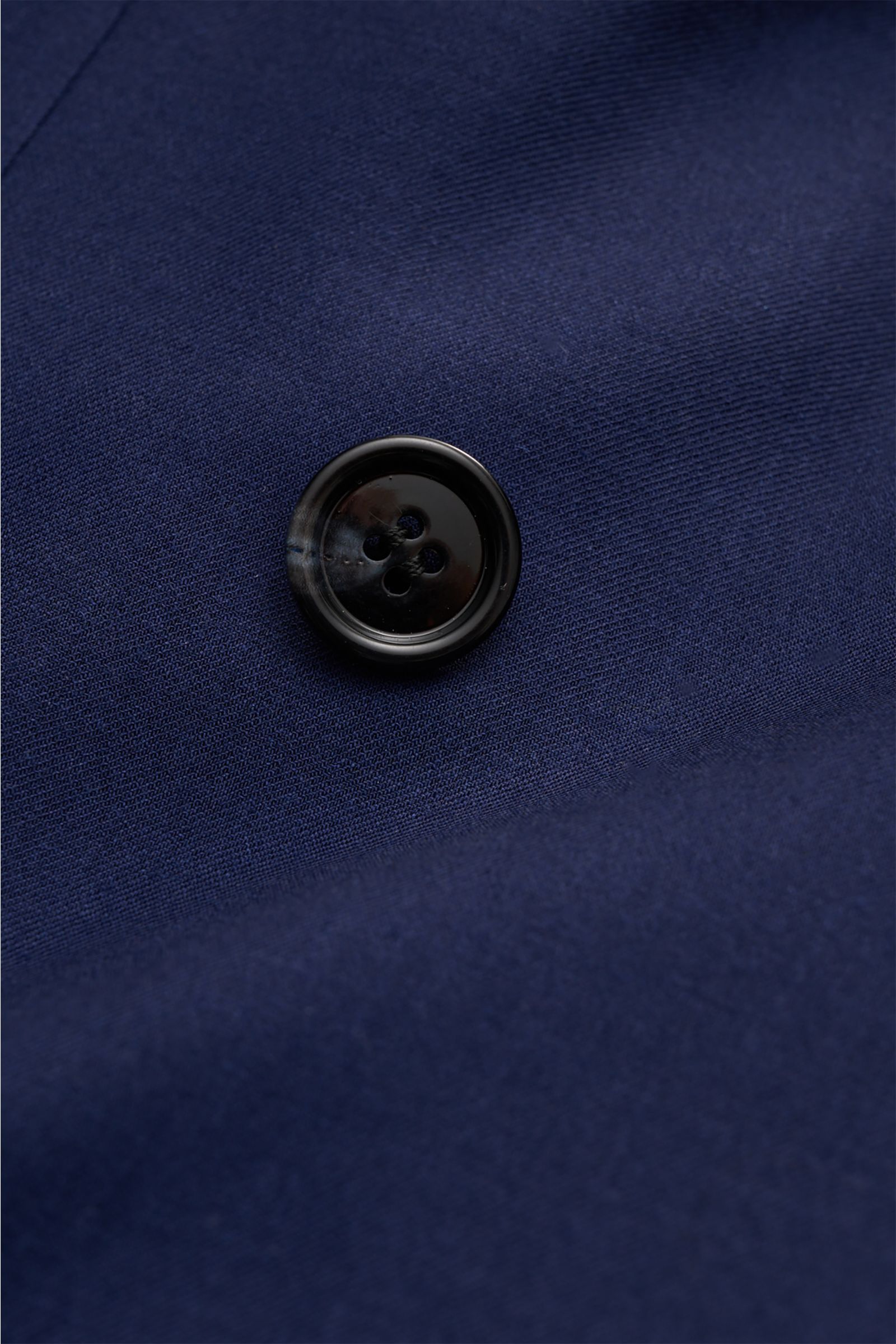 Close-up front view of the Brioni Smart-casual jacket 'New Plume' dark blue melange showing a black button on pure cashmere fabric.

Description: A linear cut and pure cashmere define the elegant appearance of the 'New Plume' double-breasted smart-casu