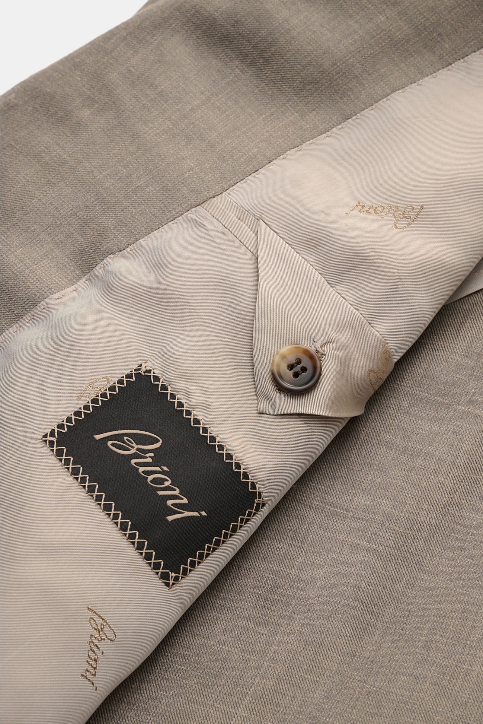 Close-up interior view of the Brioni Smart-casual jacket 'Amalfi' grey mottled showing beige silk lining, branded label, button cuff, and fine mottled silk-cashmere blend fabric. A confident choice for stylish looks: The exquisite silk-cashmere blend in a
