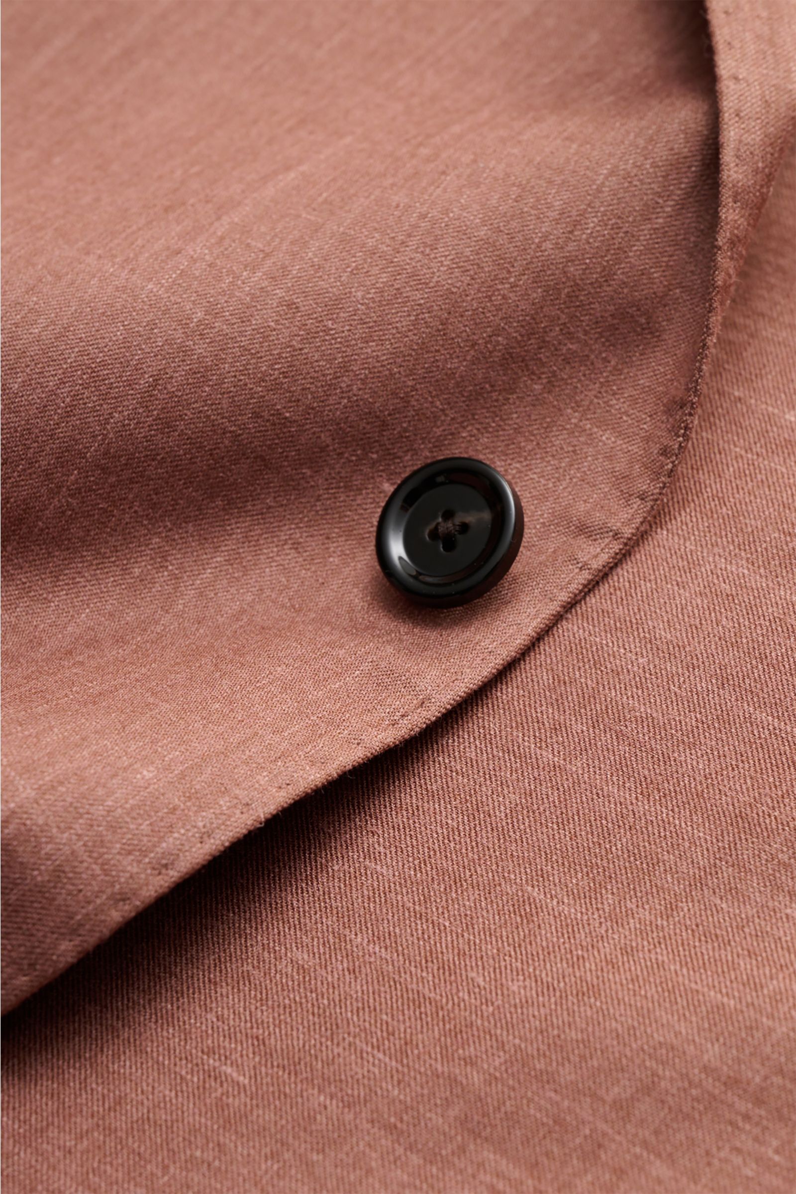 Nahaufnahme des Lardini Sakko braun meliert mit Fokus auf den schwarzen Knopf und die feine Woll-Seide-Leinen-Struktur des Stoffes.