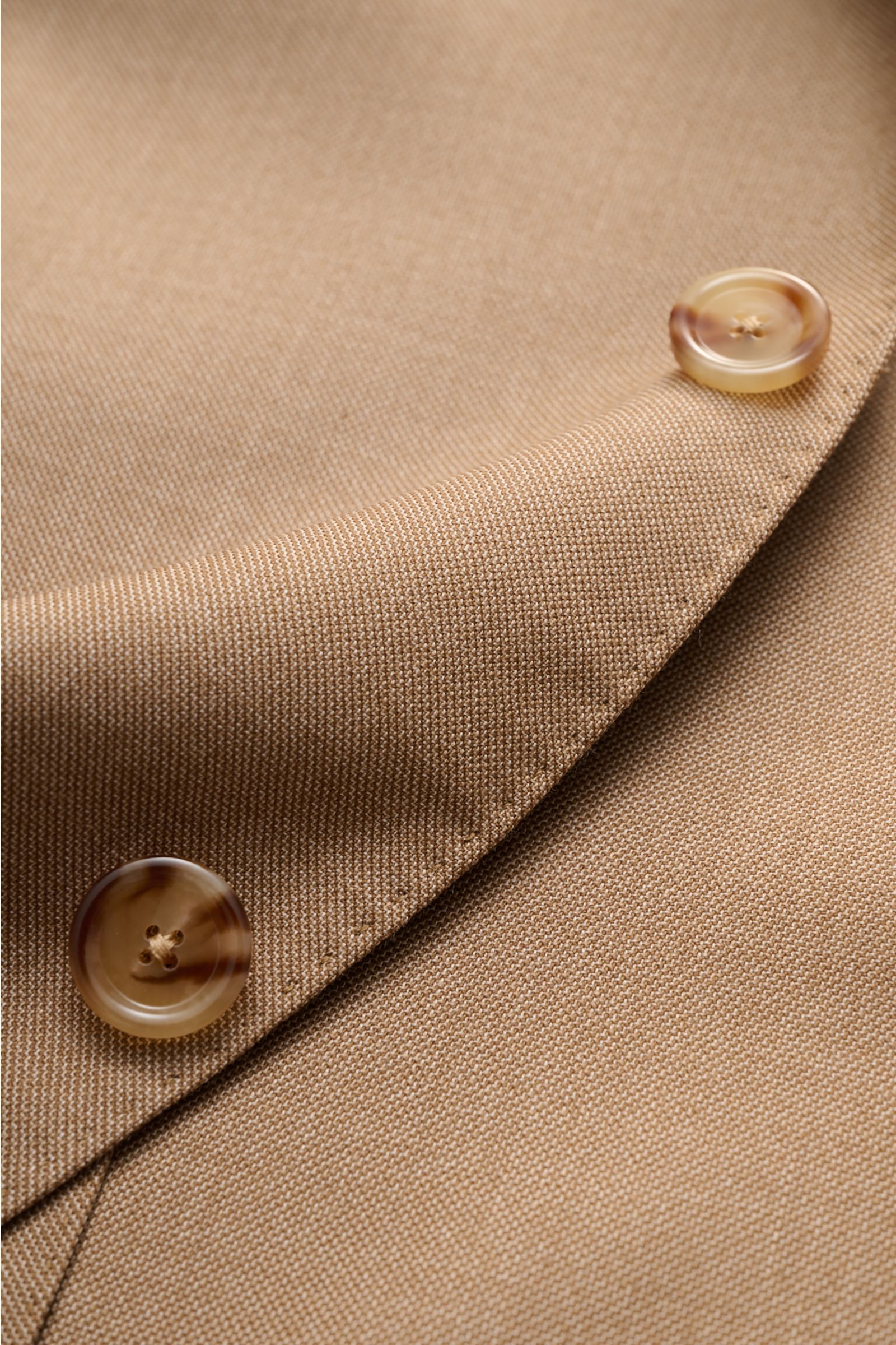 Lardini Cashmere Sakko hellbraun Nahaufnahme des fallenden Revers mit Blüten-Anstecker und Knöpfen, aus weichem, reinem Cashmere gefertigt.