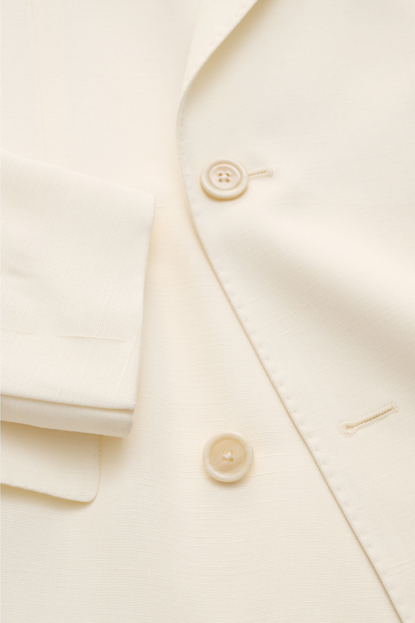 Lardini Sakko creme aus Viskose mit Seide, Slim Fit, zweireihig mit Blüten-Anstecker, Nahaufnahme von Knöpfen und Manschette, glatter Griff.