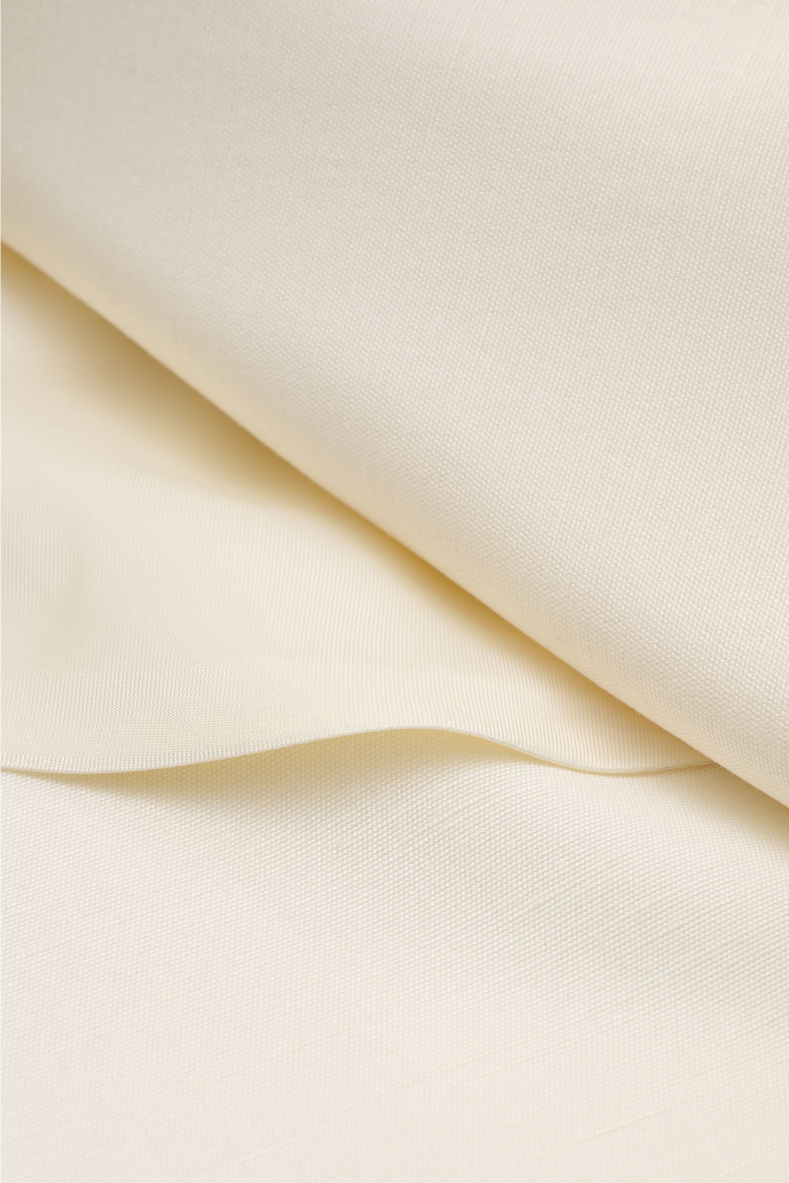 Cremefarbener Stoff des Lardini Sakko creme, luftige Viskose mit Seide, glatter Griff, fein strukturierte Textur, Nahaufnahme.