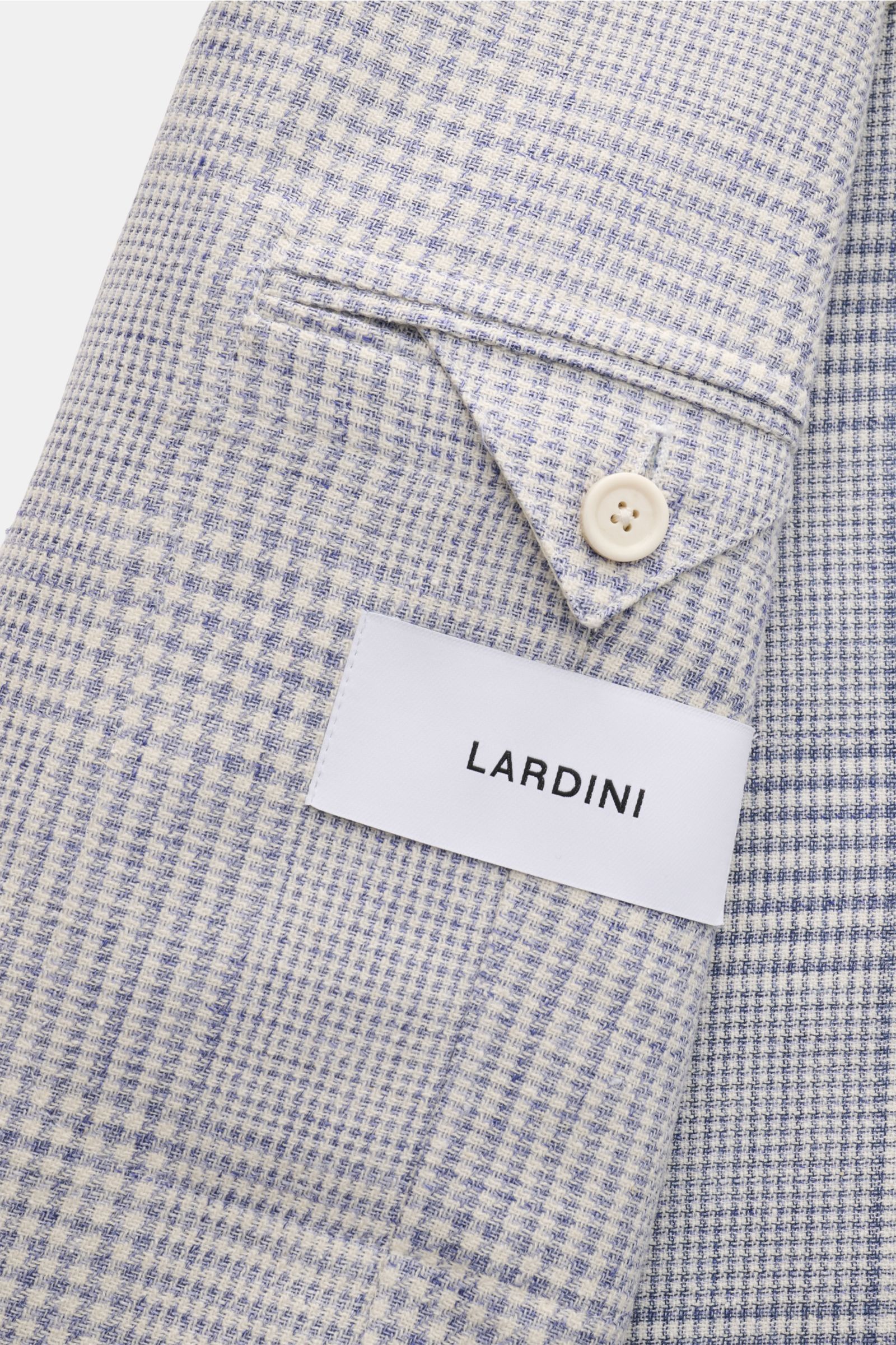 Nahaufnahme des Ärmels mit Manschettenknopf und Lardini-Label auf dem rauchblau/offwhite karierten Lardini Sakko.