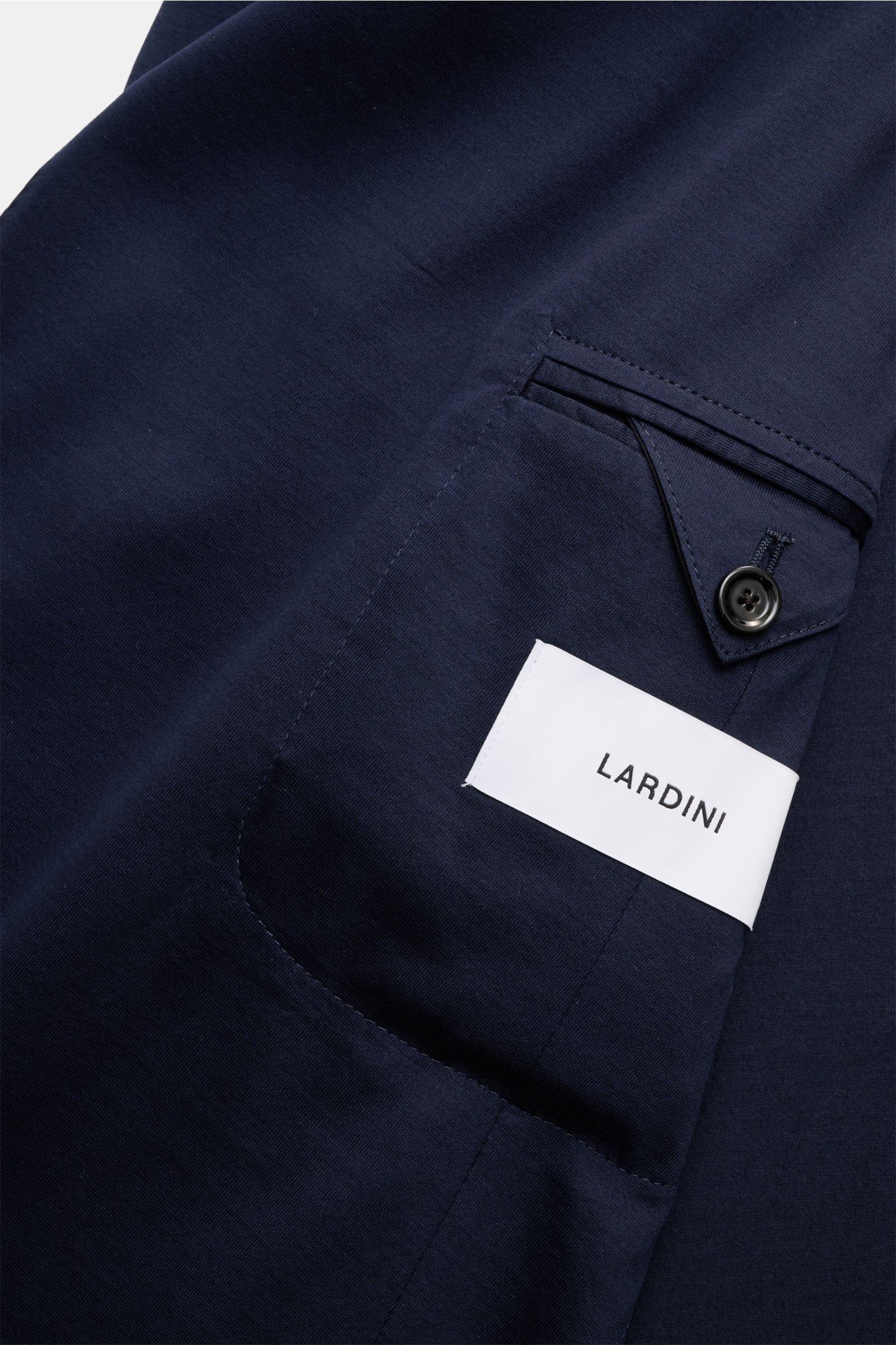 Close-up from above of the navy Lardini Jersey jacket showing the patch hip pocket with buttoned flap and LARDINI label on soft cotton jersey fabric.