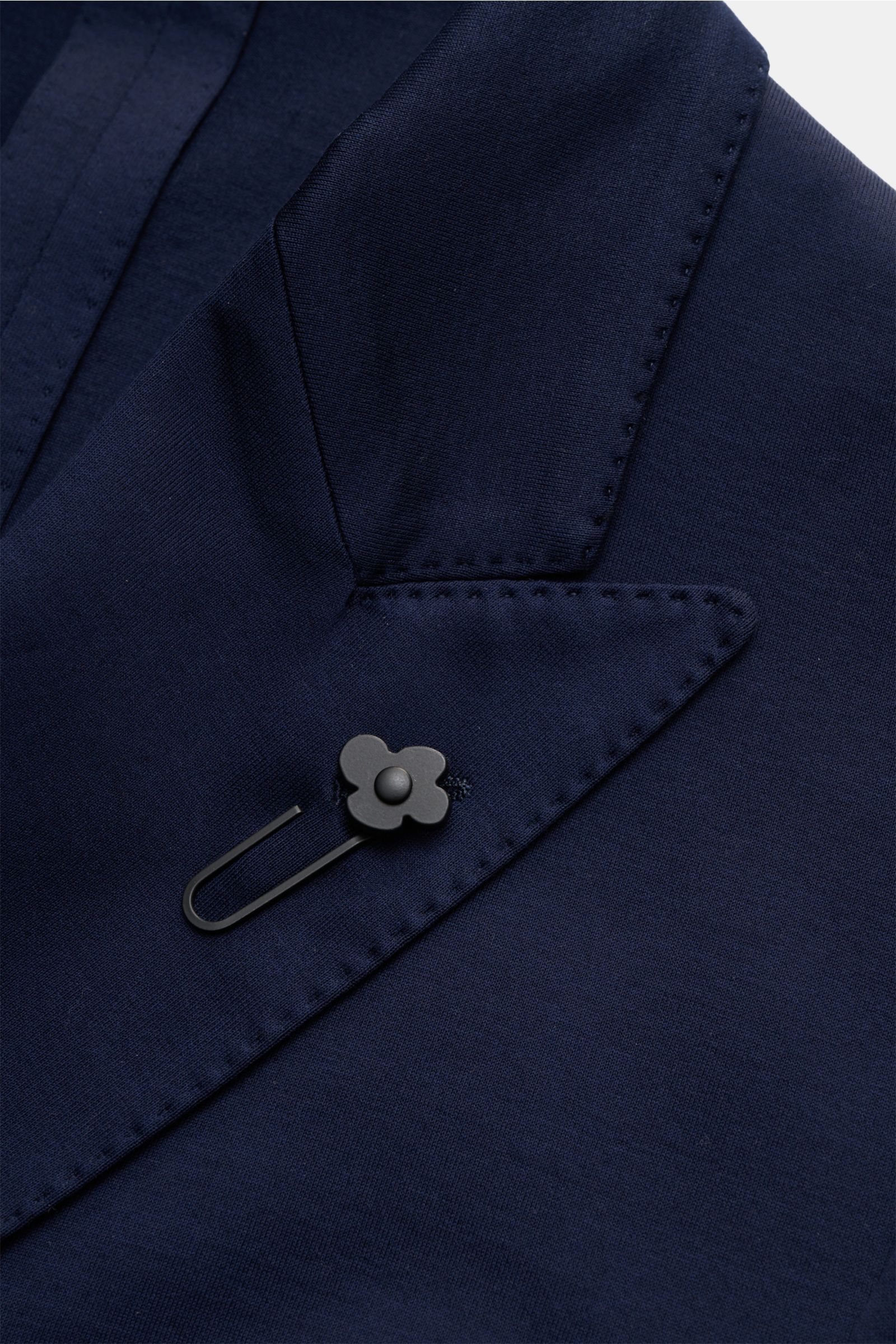 Close-up from above of the Lardini Jersey jacket navy showing the pointed lapel with a black floral pin on soft cotton jersey fabric.

Description: Comfortable and elegant: This double-breasted smart-casual jacket by LARDINI in lightweight cotton jerse