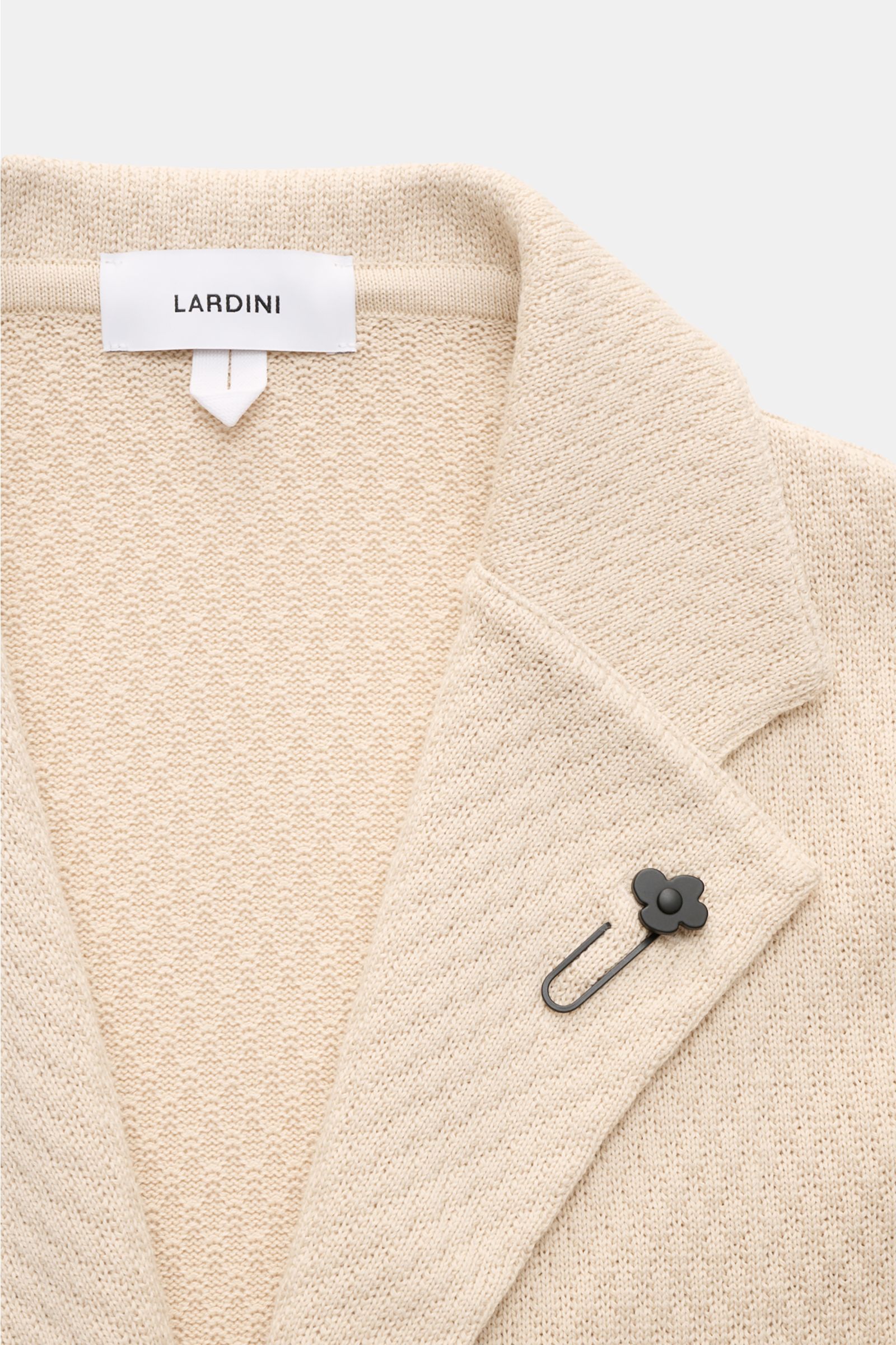 Lardini Strickblazer beige in Slim Fit, aus reiner Baumwolle mit markantem Strickmuster, fallendem Revers und Blütenpin, Nahaufnahme von vorne.