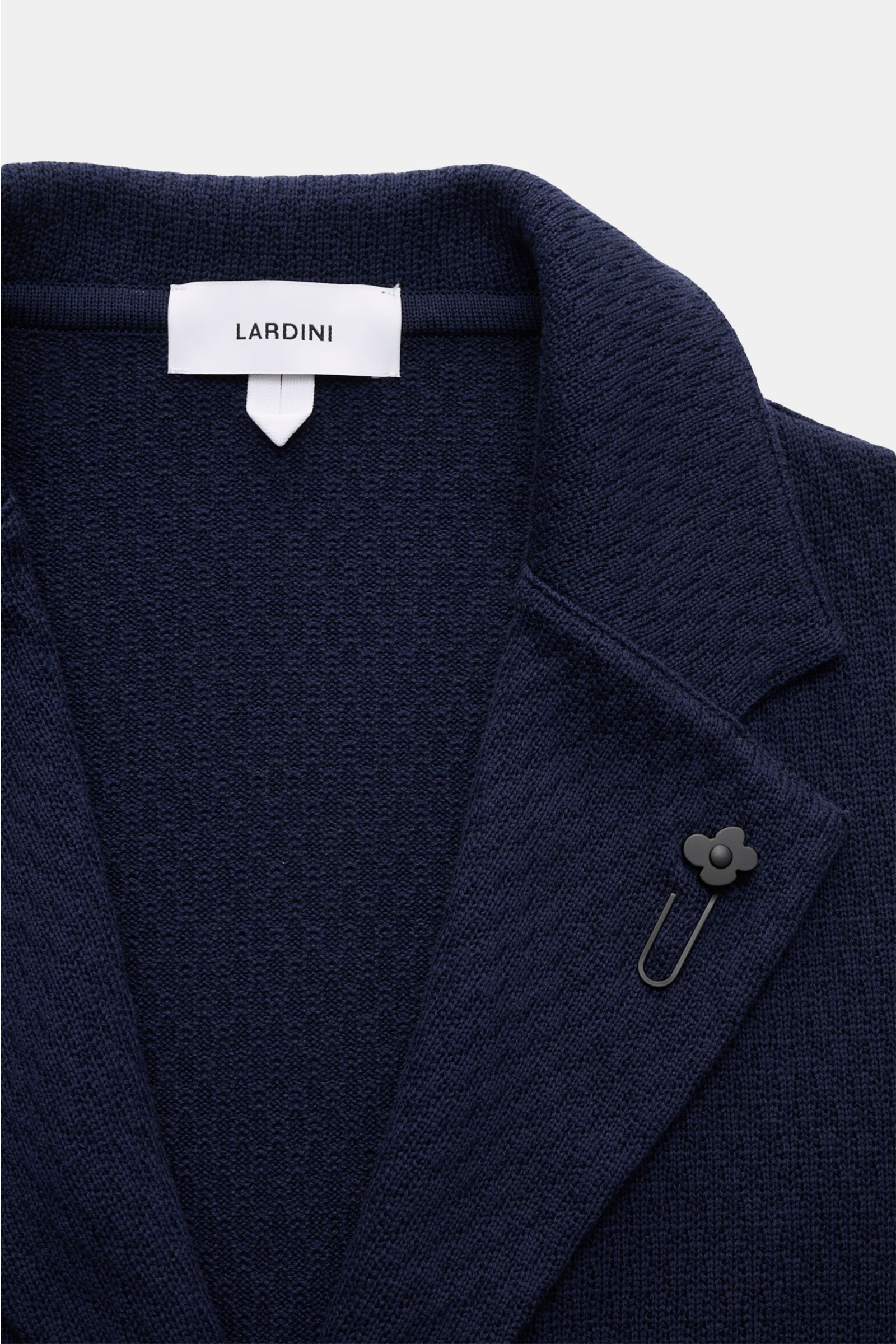 Nahaufnahme des Lardini Strickblazers navy von oben, zeigt fallendes Revers mit Blütenpin und markantes Baumwoll-Strickmuster.