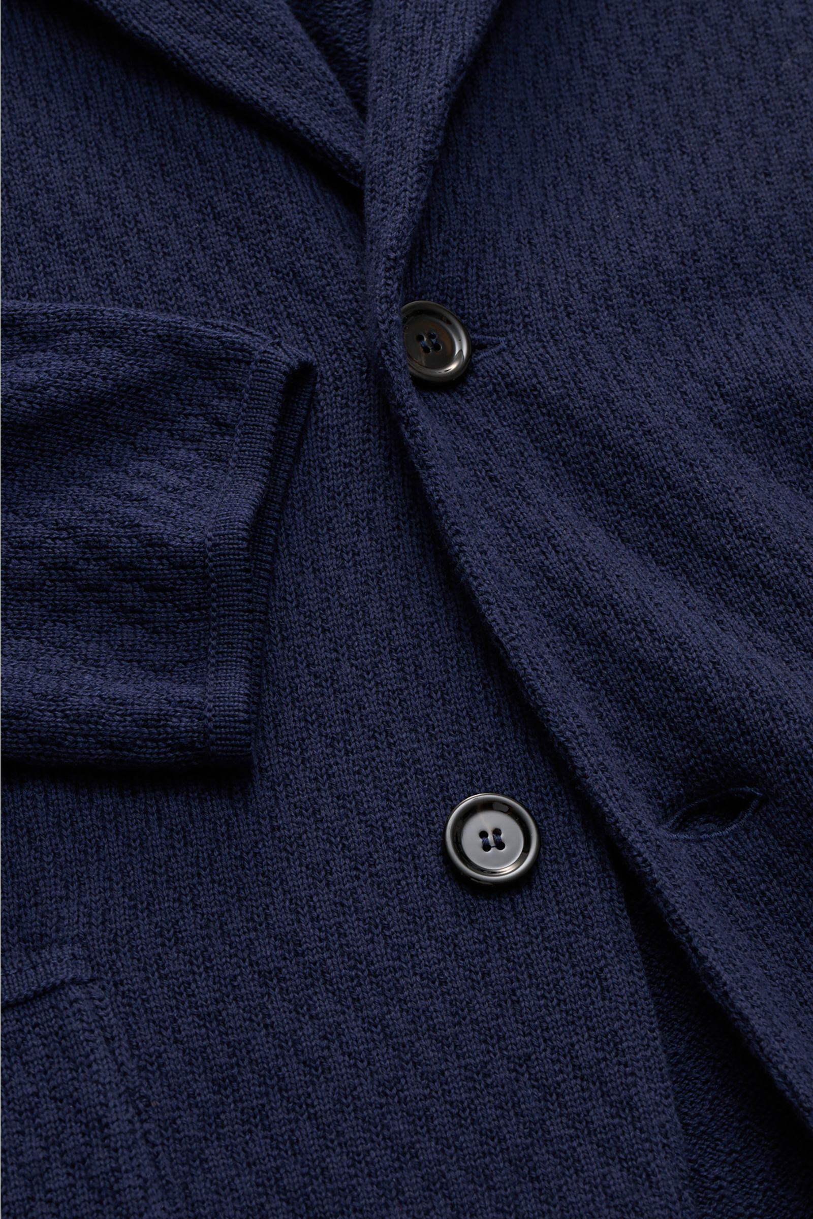 Nahaufnahme aus schräger Perspektive des Lardini Strickblazer navy, Slim Fit aus reiner Baumwolle mit markantem Strickmuster, Zwei-Knopf-Stil, fallendem Revers, aufgesetzten Hüfttaschen und griffiger Struktur.