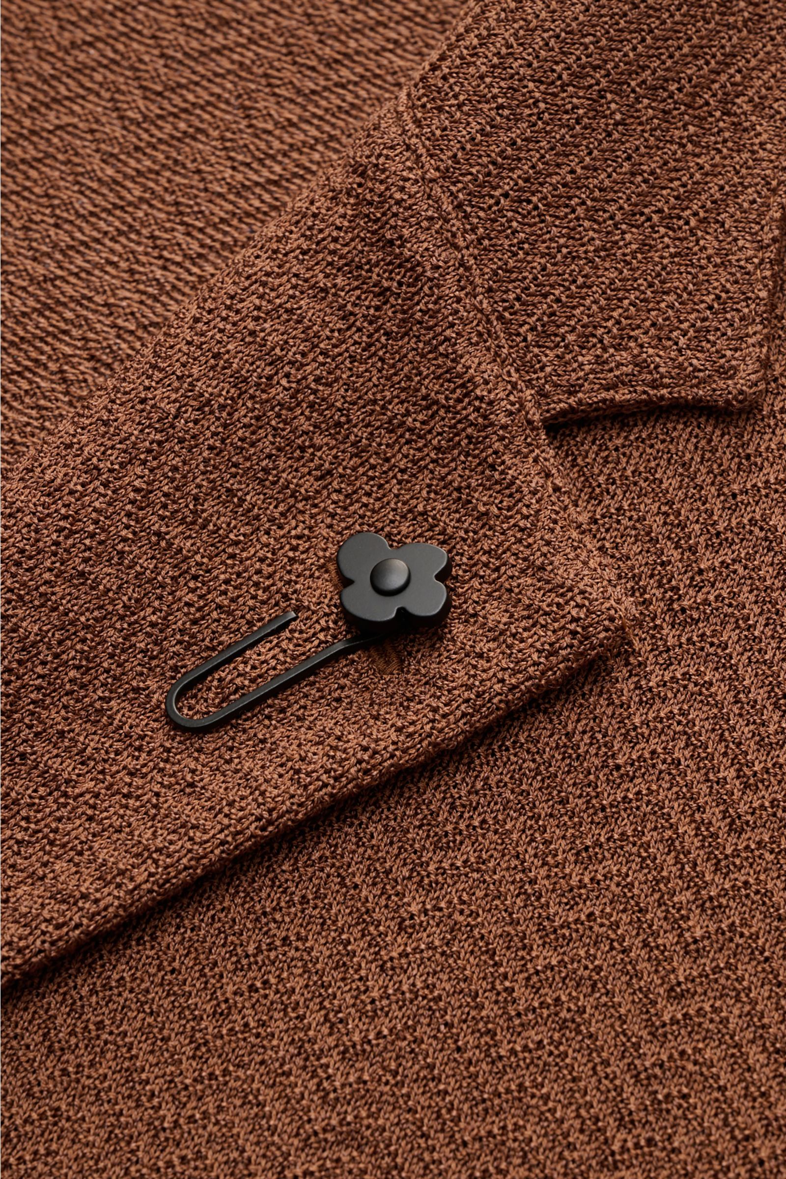 Nahaufnahme des braunen Lardini Strickblazer Slim Fit aus Baumwolle-Viskose mit Fischgrat-Strickmuster und schwarzem Blütenpin am fallenden Revers.