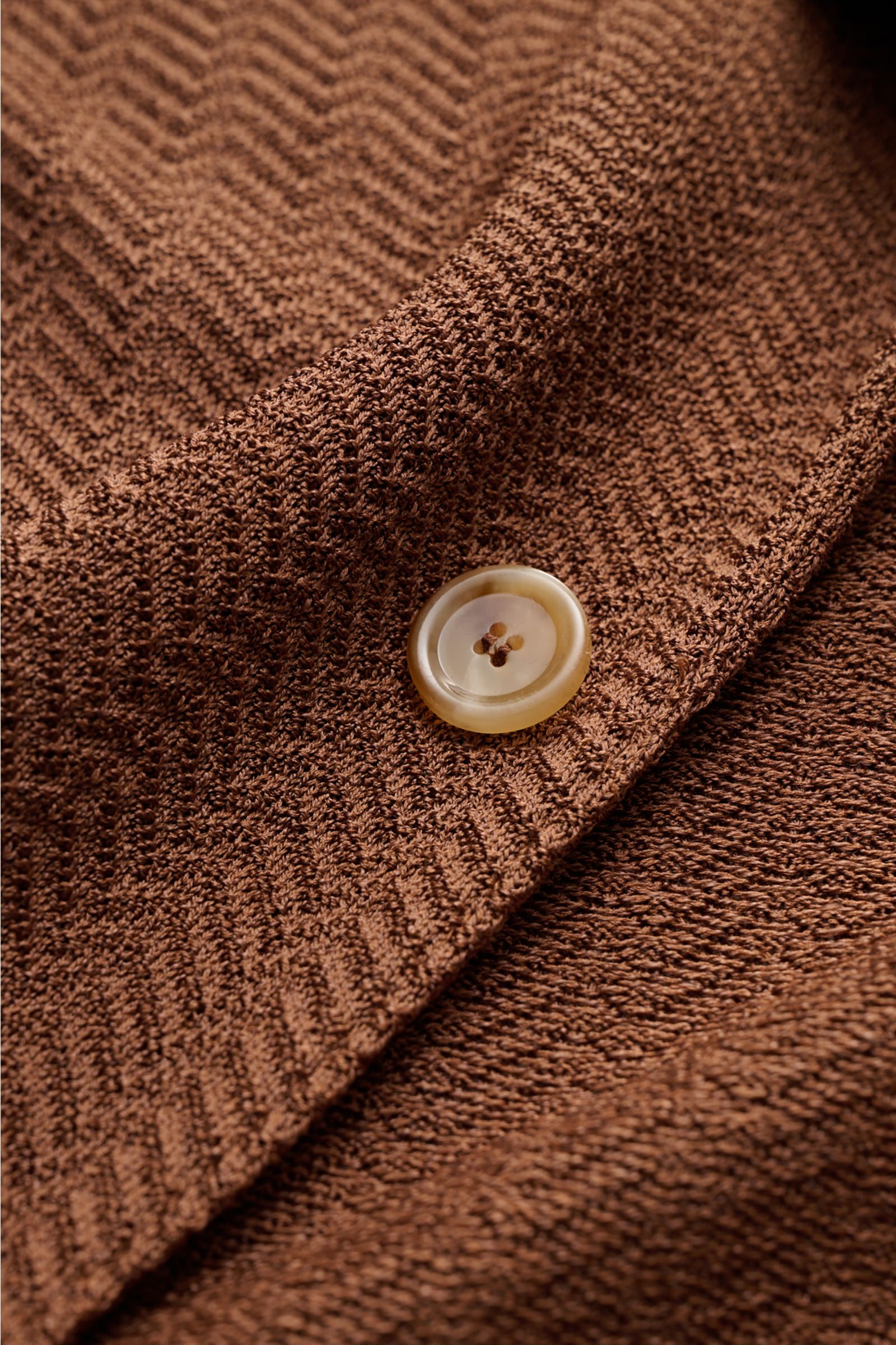Nahaufnahme des Lardini Strickblazer braun in Fischgratmuster, Fokus auf Knopf und fallendes Revers aus Baumwolle-Viskose.
