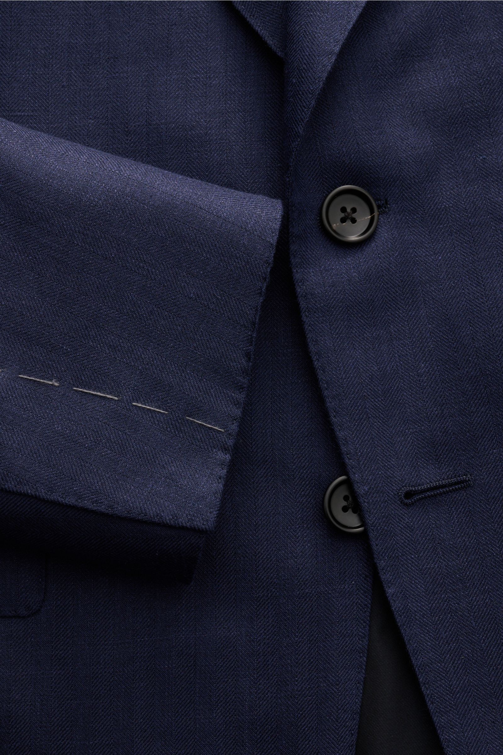 Close-up front view of the Tom Ford Sakko 'Shelton' navy jacket showing its two black buttons, soft wool-silk-linen blend with subtle herringbone pattern, slim fit, and unfinished sleeve hems. Für den souveränen Auftritt: Das Sakko 'Shelton' von TOM FO