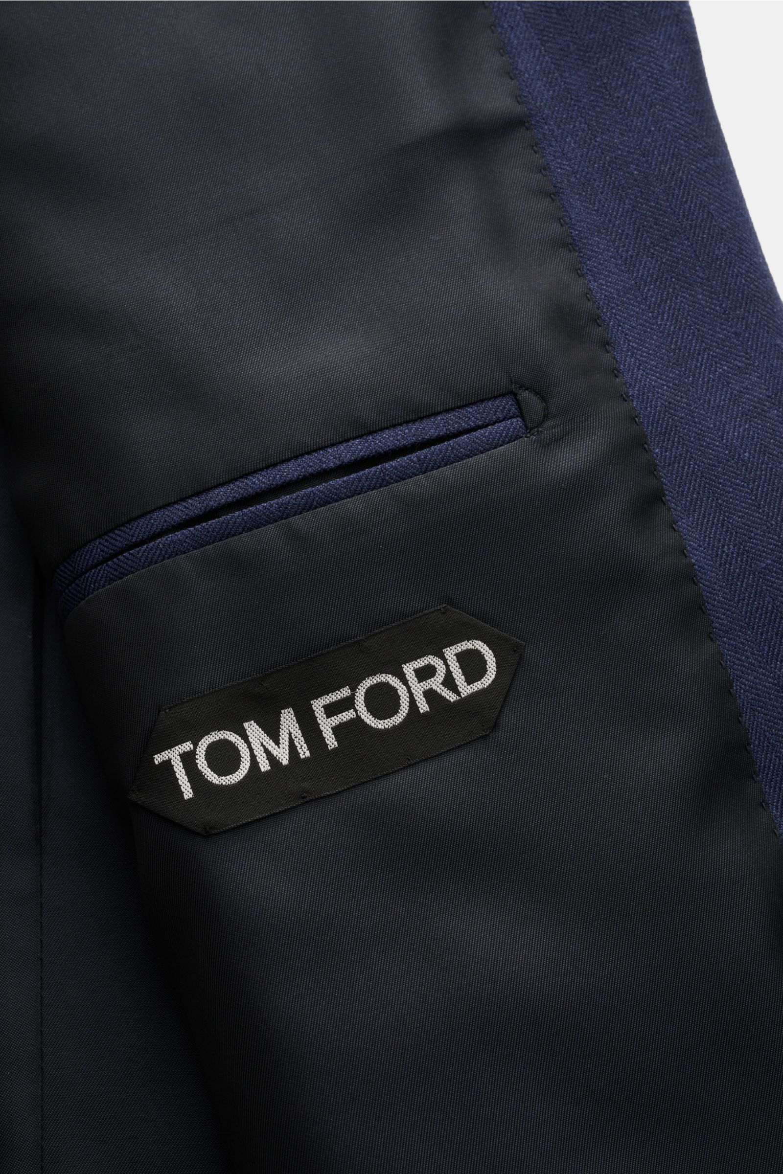 Close-up inside view of Tom Ford Sakko 'Shelton' navy jacket showing black lining, inner pocket with navy trim, and Tom Ford label.

Für den souveränen Auftritt: Das Sakko 'Shelton' von TOM FORD aus edlem Woll-Mix besticht durch seine luxuriöse Materia
