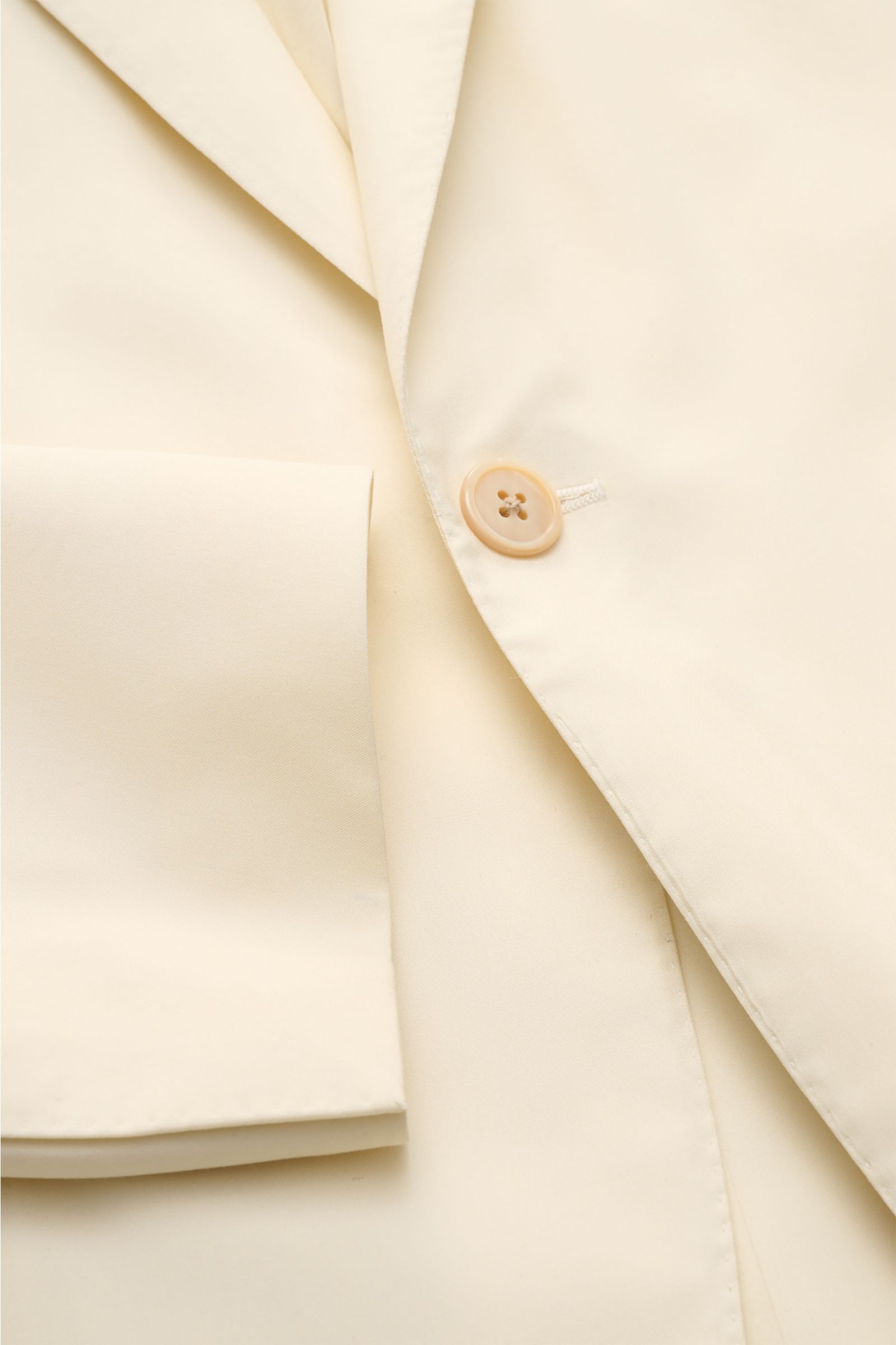 Belvest Seiden-Sakko creme aus reiner Seide, Slim Fit, taillierter Ein-Knopf-Stil mit Perlmuttknopf, Spitzrevers, Brust- und Hüfttaschen, Detailaufnahme.