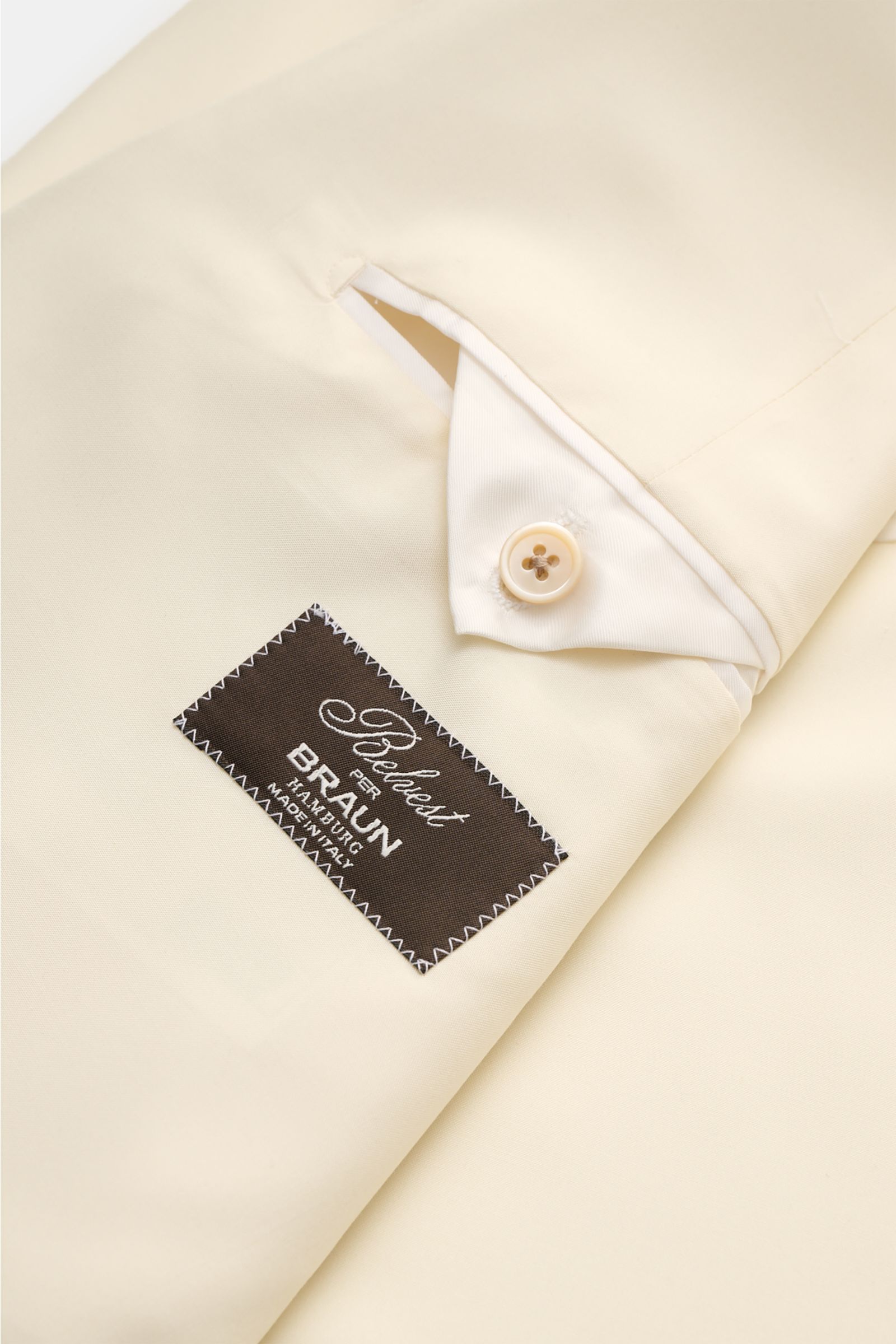 Nahaufnahme des Belvest Seiden-Sakko creme von innen, zeigt Innentaschen, Perlmuttknopf, glatten Griff, Slim Fit und Etikett von Braun Hamburg.