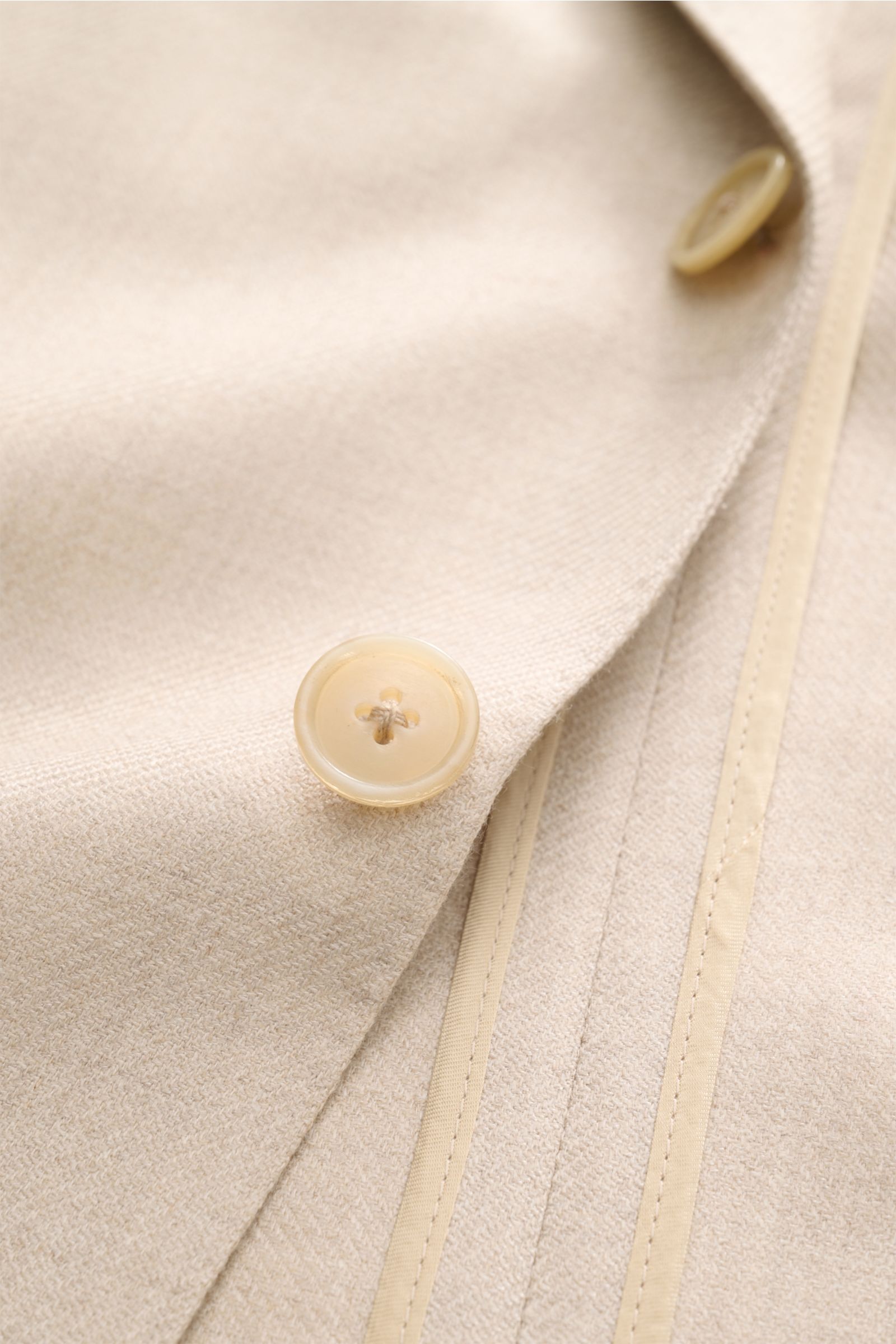 Belvest Cashmere Sakko beige in Nahaufnahme von oben, zeigt weichen Cashmere-Seidenmix, Slim Fit, Ein-Knopf, Revers mit Pin und Taschen.