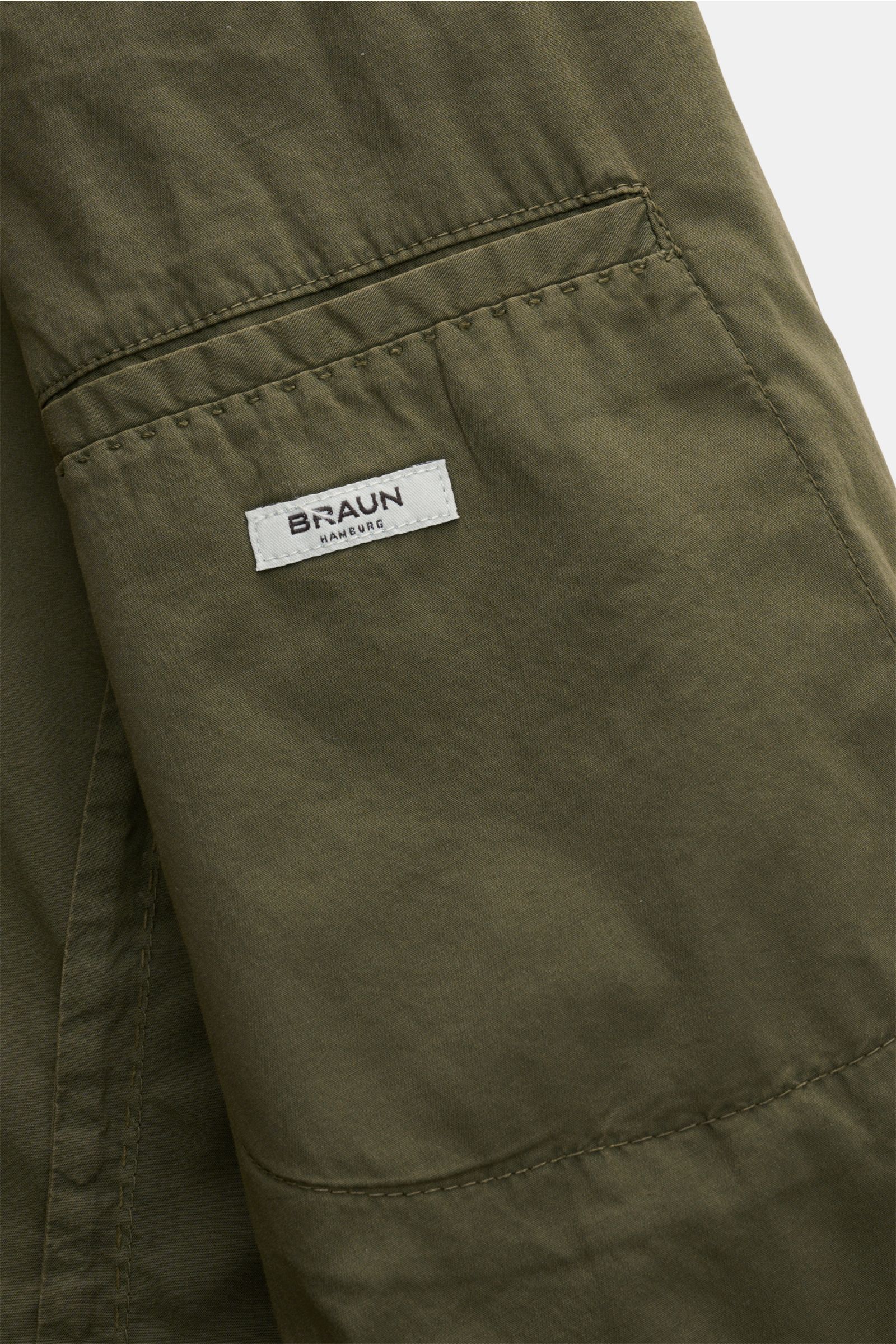 Nahaufnahme des Innenfutters vom Boglioli Sakko 'K. Jacket' oliv mit Label, praktische Innentasche aus leichtem Baumwoll-Stretchgewebe.