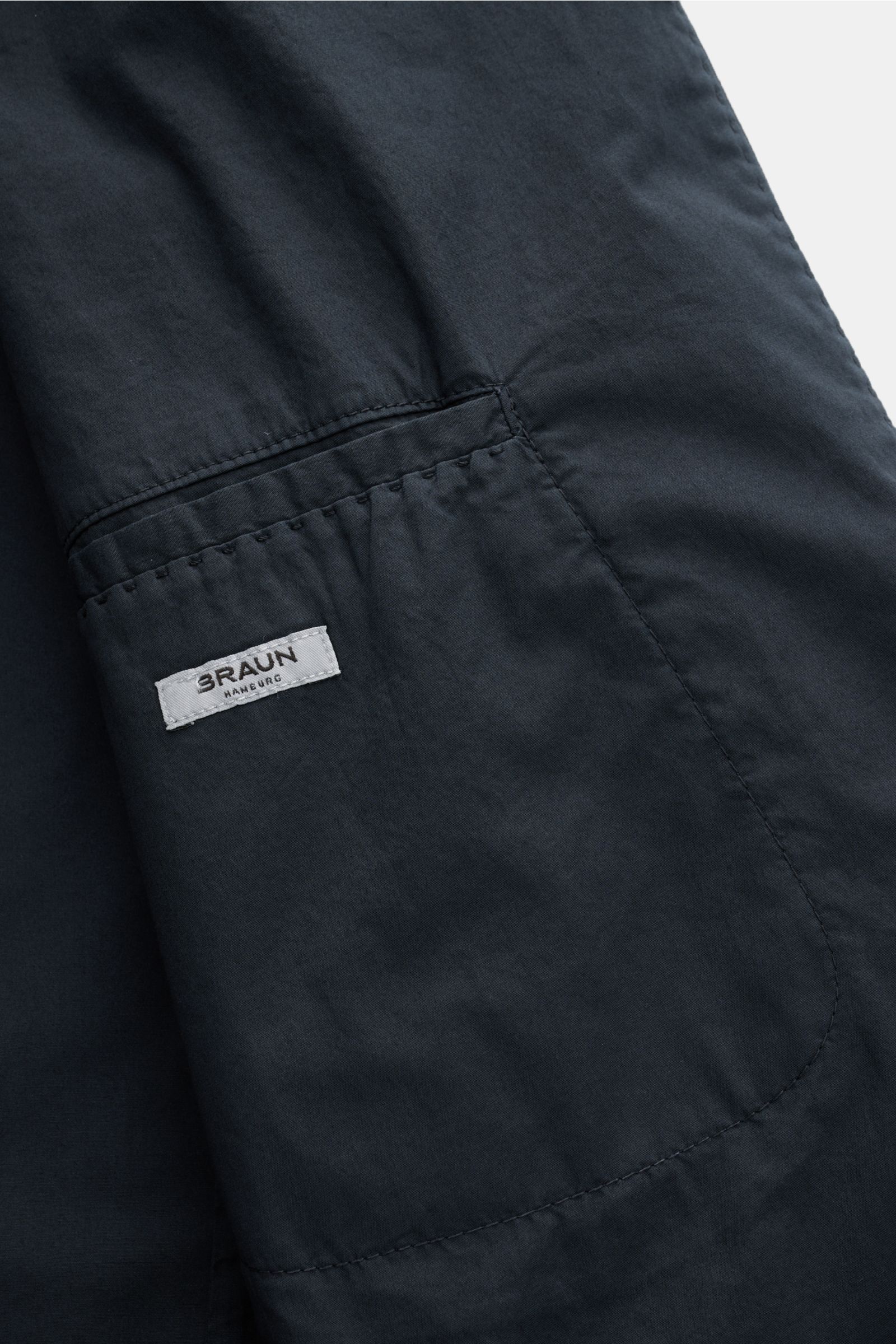 Nahaufnahme des Innenfutters mit zwei Innentaschen und BRAUN-Label des Boglioli Sakko 'K. Jacket' navy aus leichtem Baumwoll-Stretch.