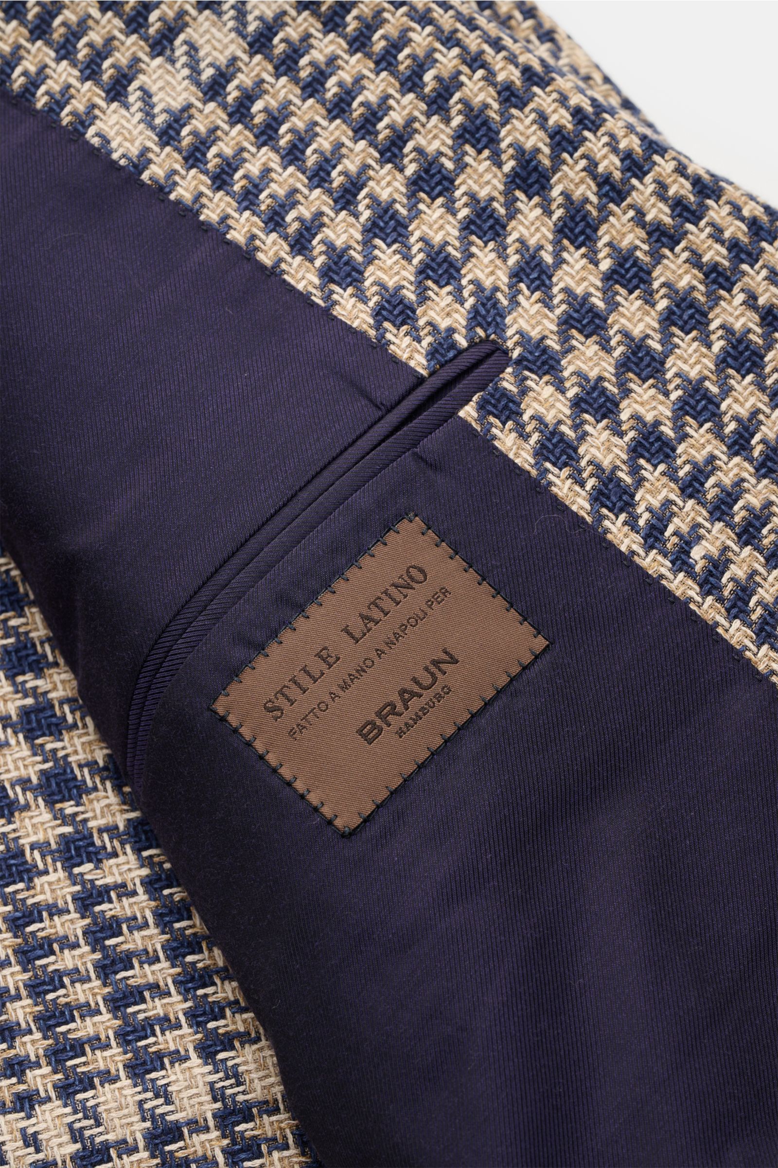 Close-up angled view of Stile Latino Smart-casual jacket 'Vincenzo' navy/beige checked showing silk blend fabric and inside pocket with label.

STILE LATINO presents luxury you can feel with its lightweight smart-casual jacket 'Vincenzo' in a fine silk bl