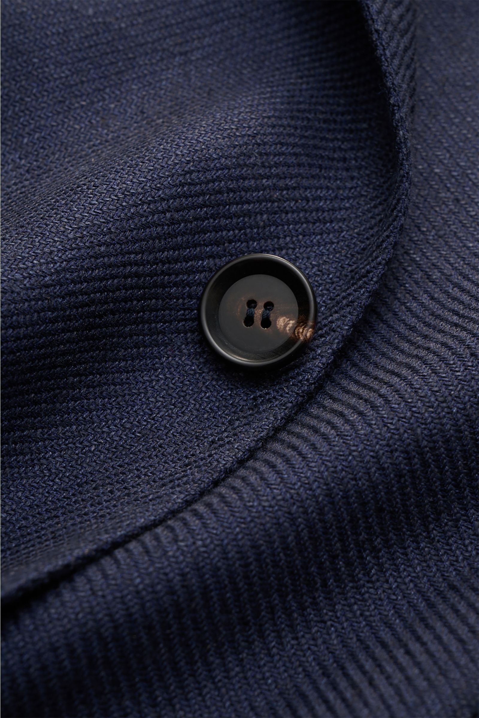 Close-up front view of the Sipario Sakko 'Ginza' navy showing fine textured navy fabric and a black button, highlighting its lightweight linen, silk, and cotton mix.

Leichtigkeit mit Stil: Das Sakko 'Ginza' von SIPARIO setzt auf eine reduzierte, ungef