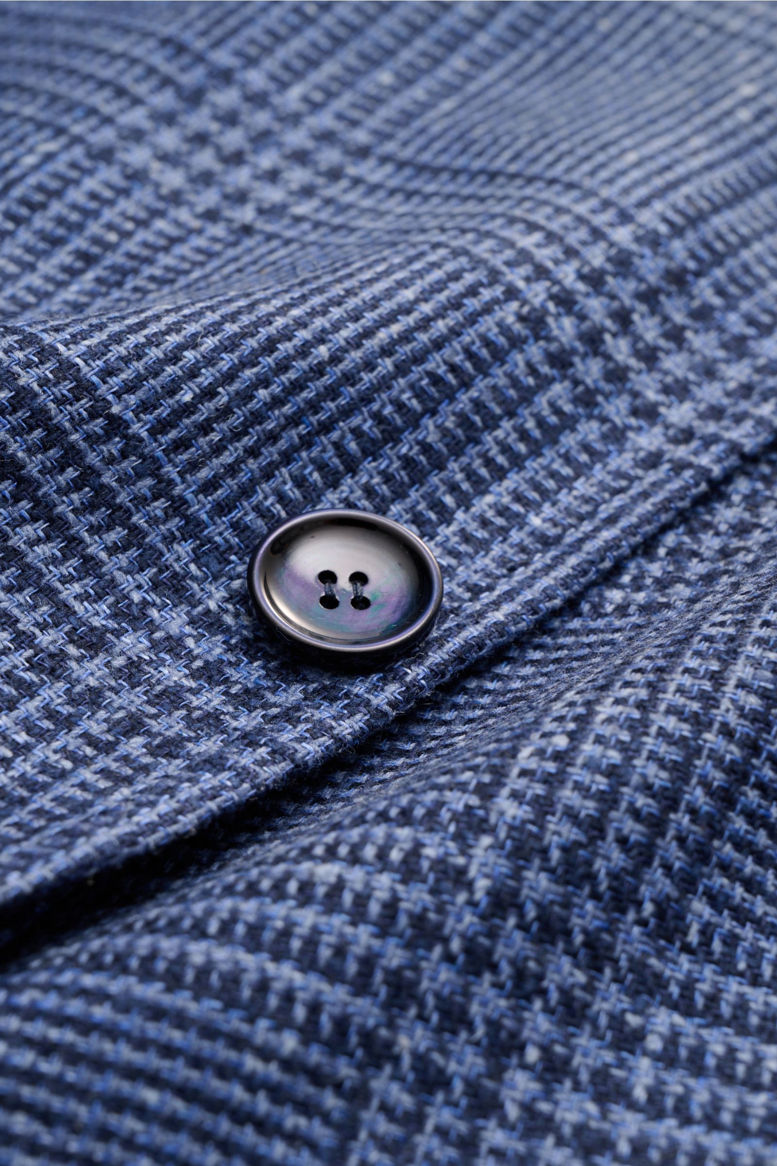 Close-up front view of the Sipario Smart-casual jacket 'Ginza' grey-blue/black checked showing a four-hole button and detailed linen-silk glen check fabric texture. Lightweight and stylish: The smart-casual jacket 'Ginza' by SIPARIO features classic glen 
