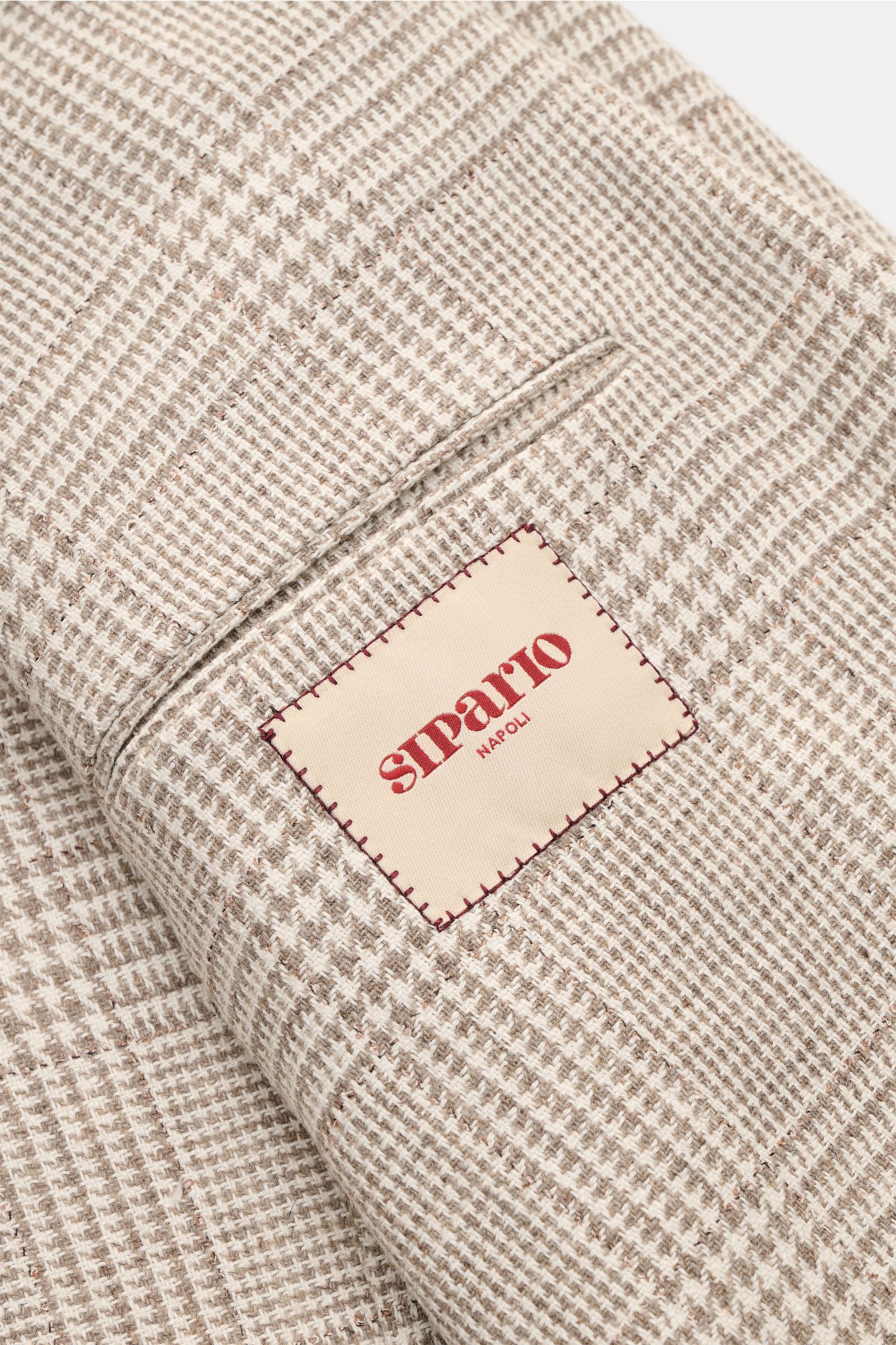 Close-up angled view of Sipario Smart-casual jacket 'Ginza' taupe/cream checked showing classic glen check fabric and label.

Lightweight and stylish: The smart-casual jacket 'Ginza' by SIPARIO features classic glen check in a lightweight design made o