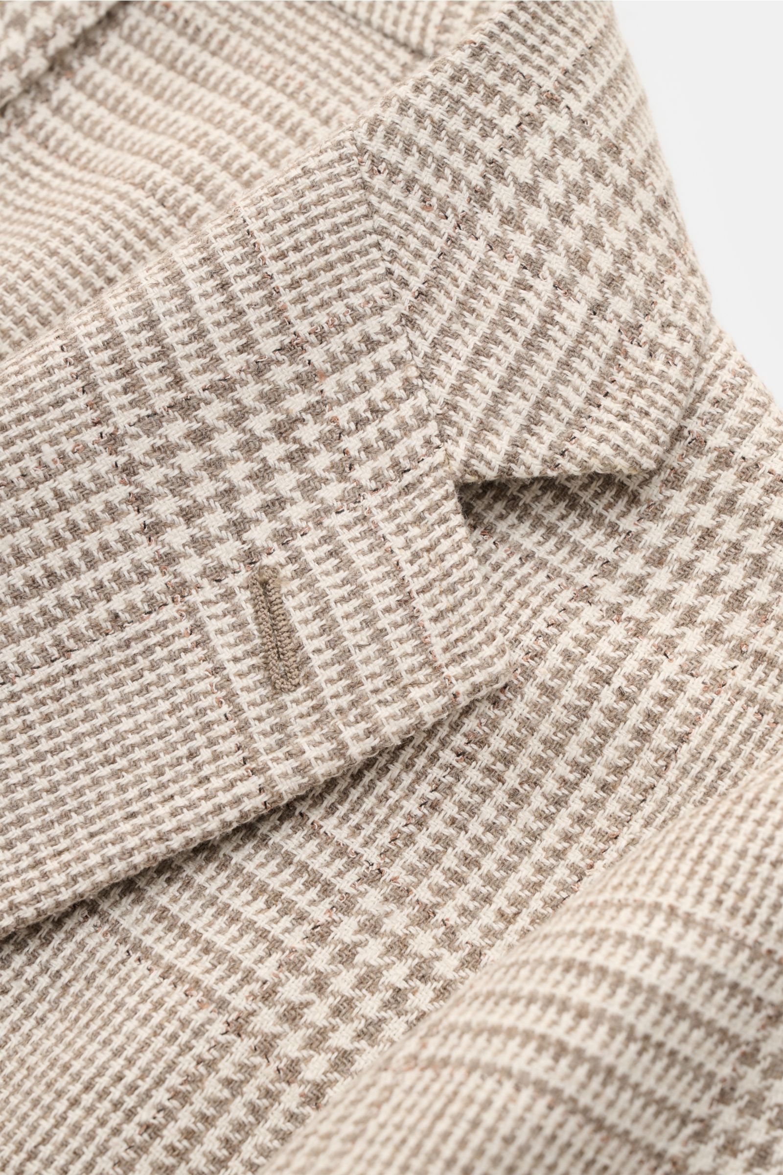 Close-up image of the lapel and chest area of the Sipario Smart-casual jacket 'Ginza' taupe/cream checked, photographed from a top front angle. Lightweight and stylish: The smart-casual jacket 'Ginza' by SIPARIO features classic glen check in a lightweigh
