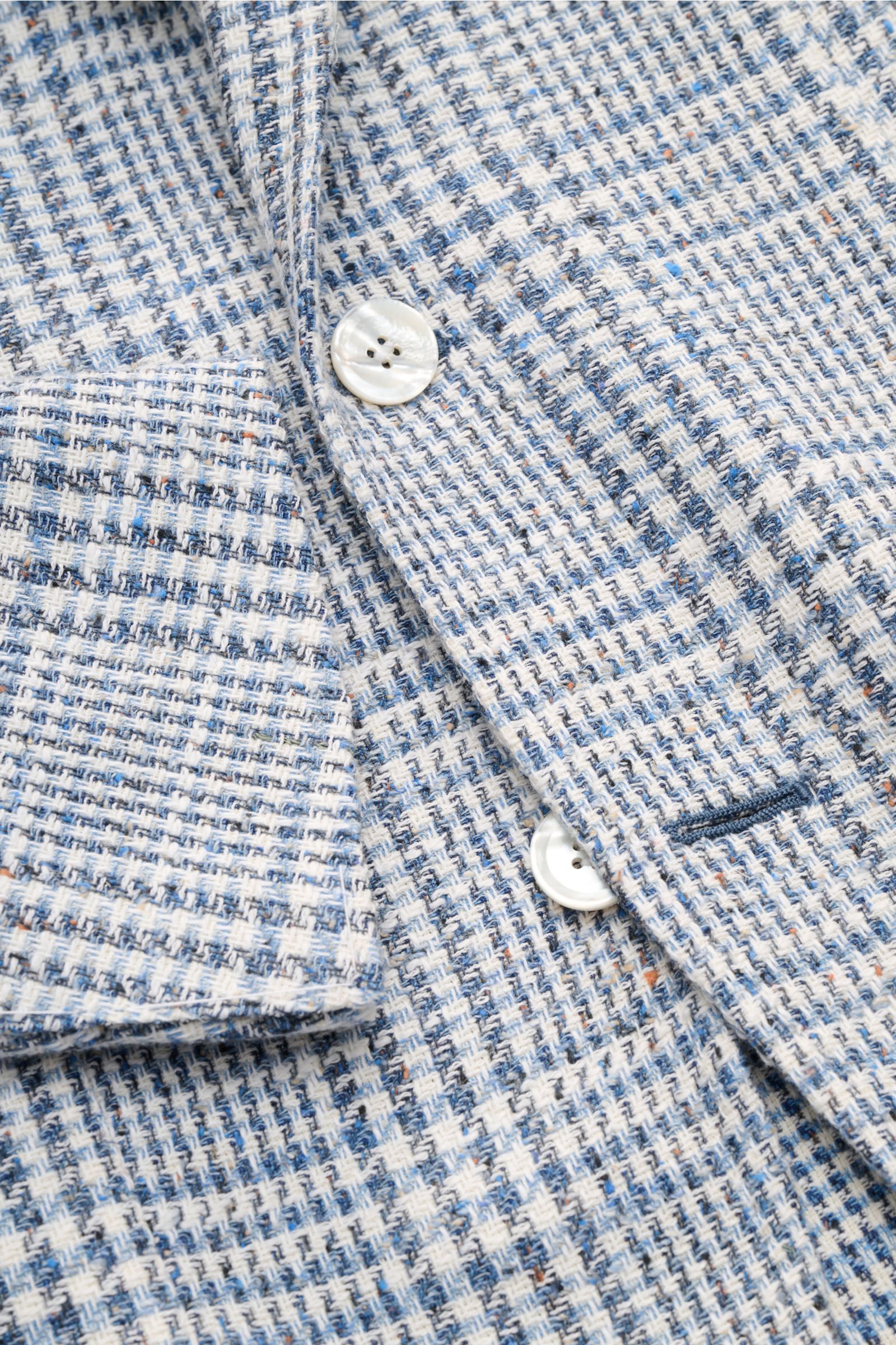 Close-up front-side view of the Sipario Smart-casual jacket 'Ginza' grey-blue/off-white checked, showing textured lightweight cotton Panama fabric and mother-of-pearl buttons.

Structure with style: The smart-casual jacket 'Ginza' by SIPARIO in lightwe