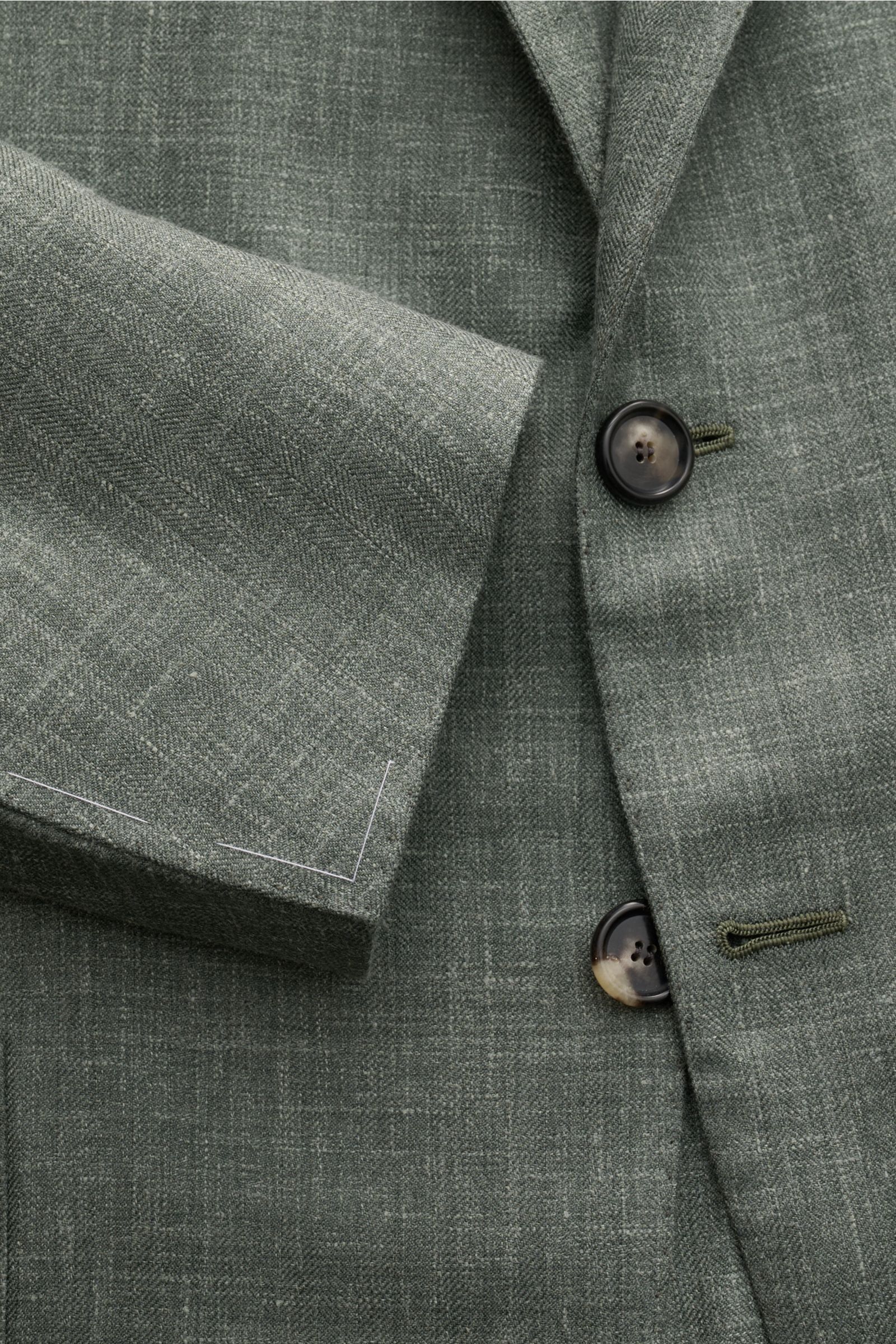Nahaufnahme des Cesare Attolini Sakko graugrün meliert in Slim Fit, tailliert mit fallendem Revers und feinem tonalen Webmuster.