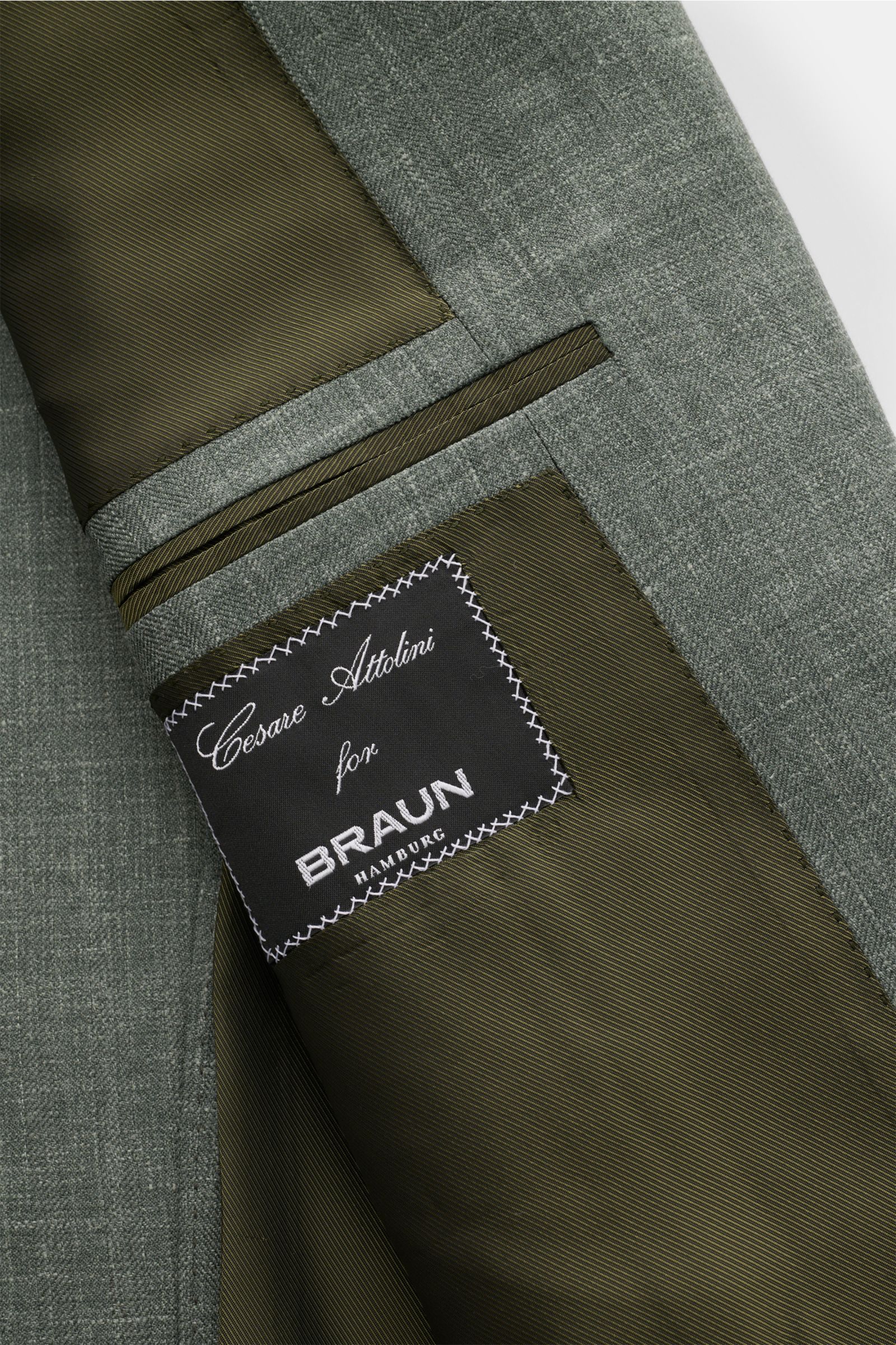 Cesare Attolini Sakko graugrün meliert, Detailansicht innen mit feiner Wolle-Seide-Leinen-Mischung, Etikett und Innentaschen sichtbar.