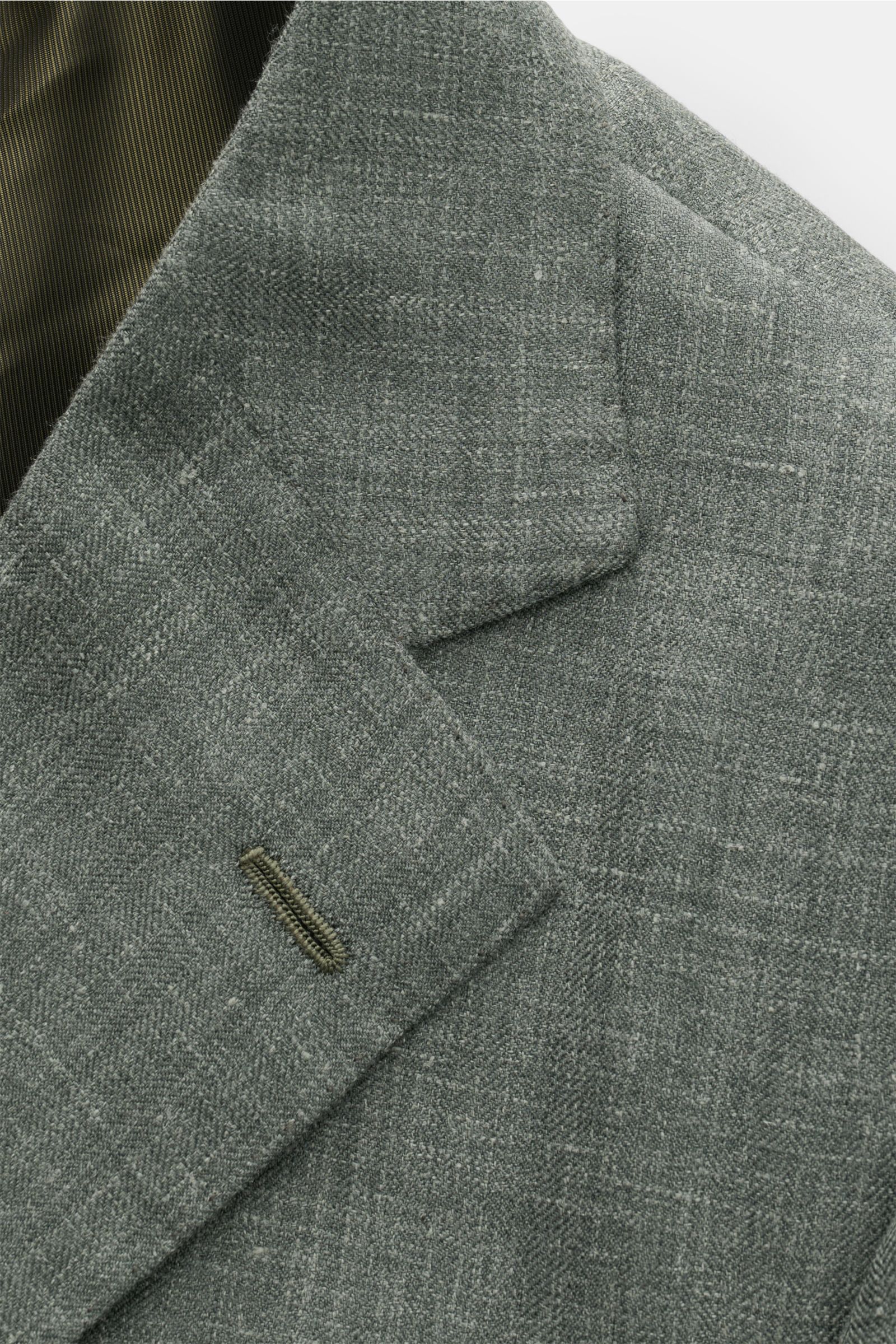 Nahaufnahme des Cesare Attolini Sakko graugrün meliert mit feinem Woll-Seiden-Leinen-Mix, fallendem Revers und tonalem Webmuster.