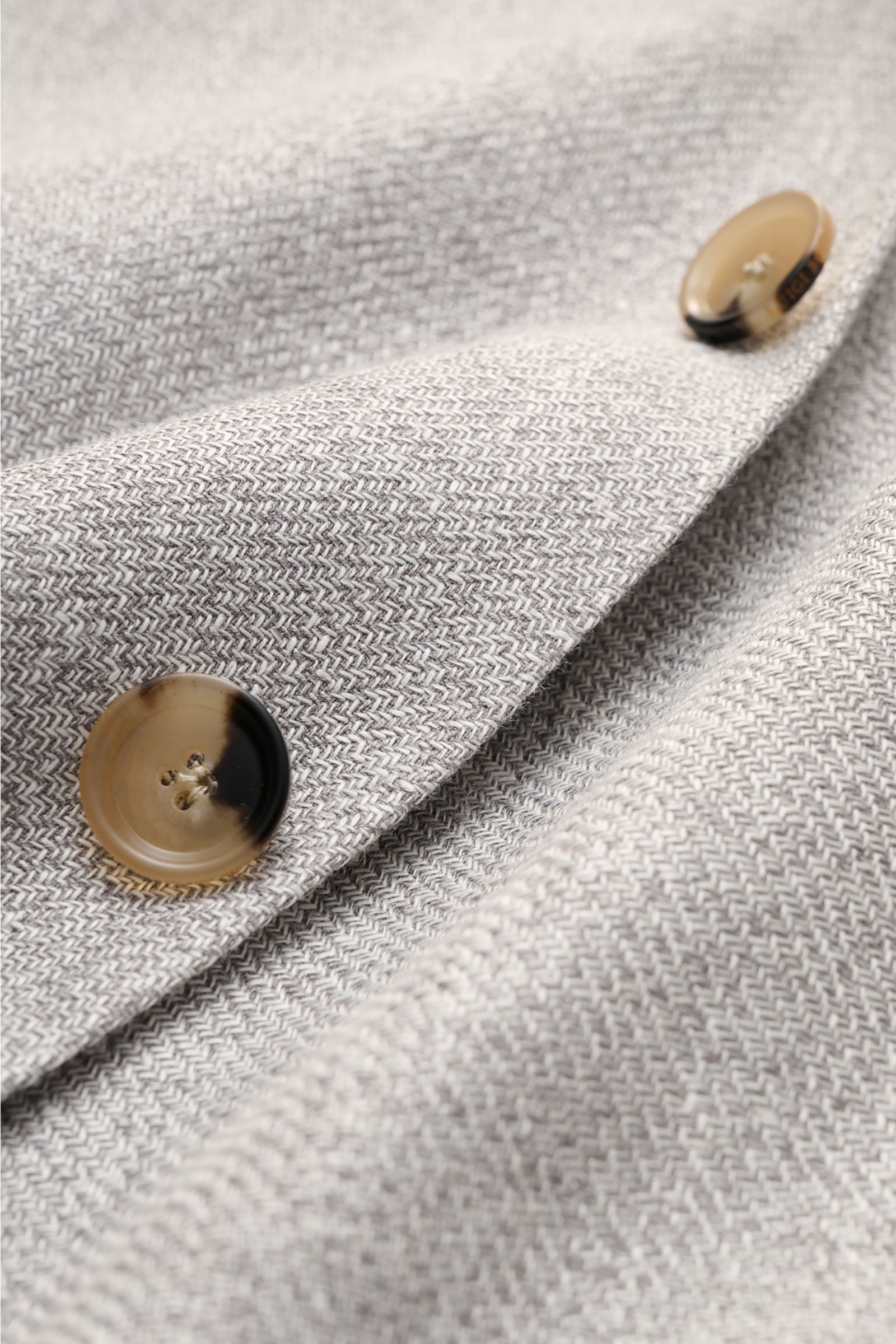 Close-up front angle of Borrelli Smart-casual jacket 'Procida' grey/off-white mottled, showing textured linen-silk-cotton fabric and buttons. Business elegance in a summery design: With its lightweight material and exceptional feel, the smart-casual jacke