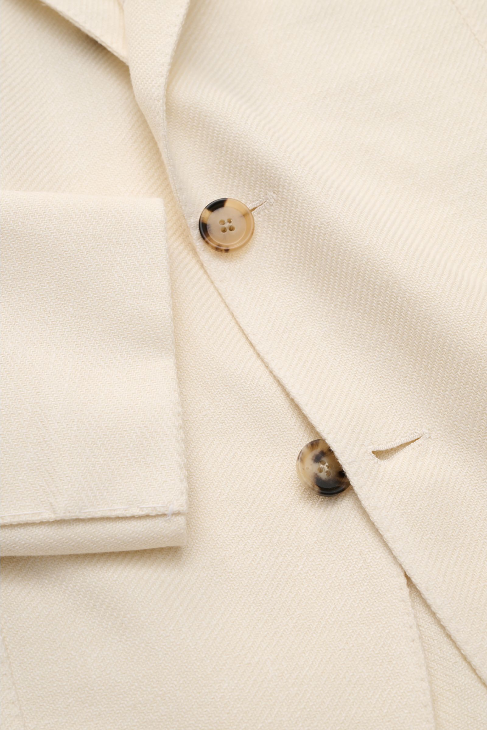Close-up top view of Borrelli Smart-casual jacket 'Procida' cream showing texture, buttons, and lapel detail.

Description: Business elegance in a summery design: With its lightweight material and exceptional feel, the smart-casual jacket 'Procida' by 