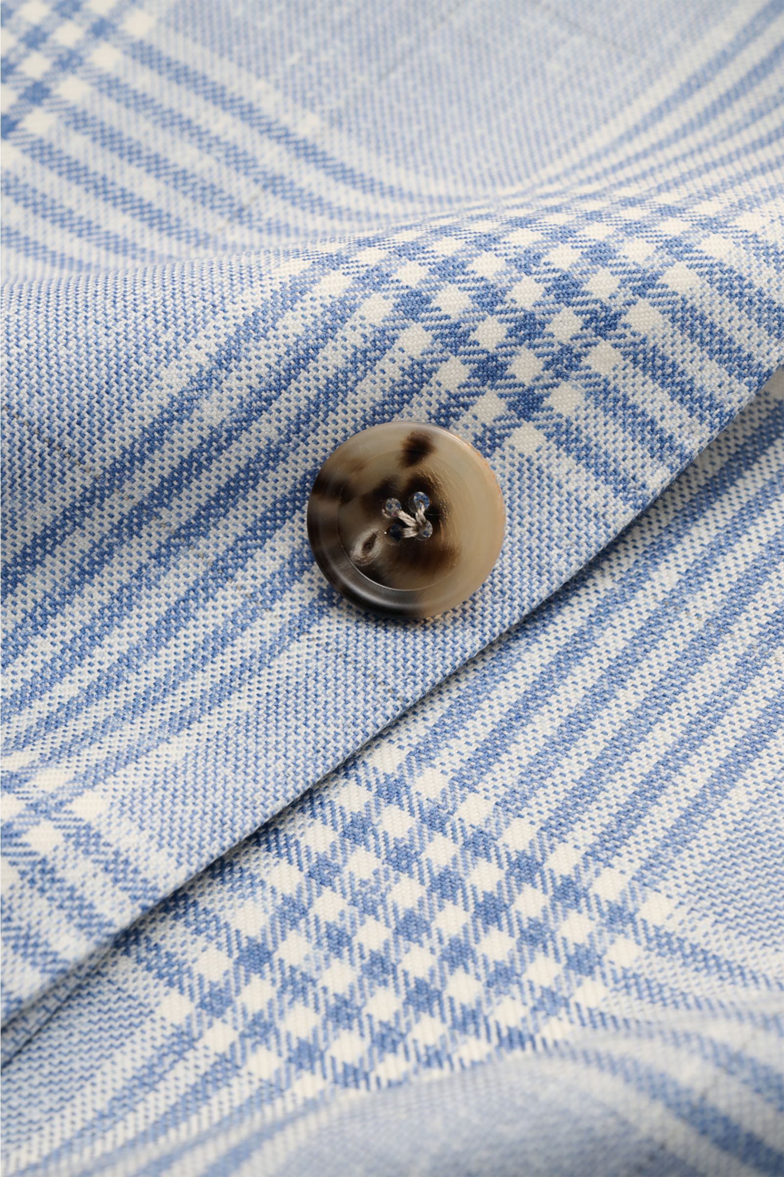 Nahaufnahme des Borrelli Sakko 'Procida' rauchblau/offwhite kariert mit Glencheck-Muster und Hornknopf, weiche Wolle-Cashmere-Qualität.