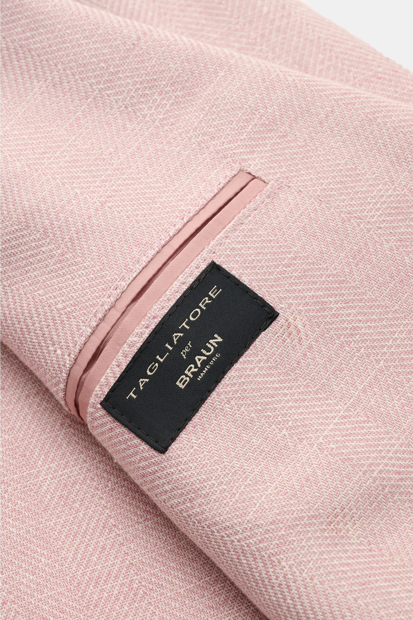 Nahaufnahme des Tagliatore Sakkos 'Monte Carlo' altrosa meliert mit markanter Fischgrat-Webstruktur und schwarzem Markenlabel, fotografiert von schräg oben.