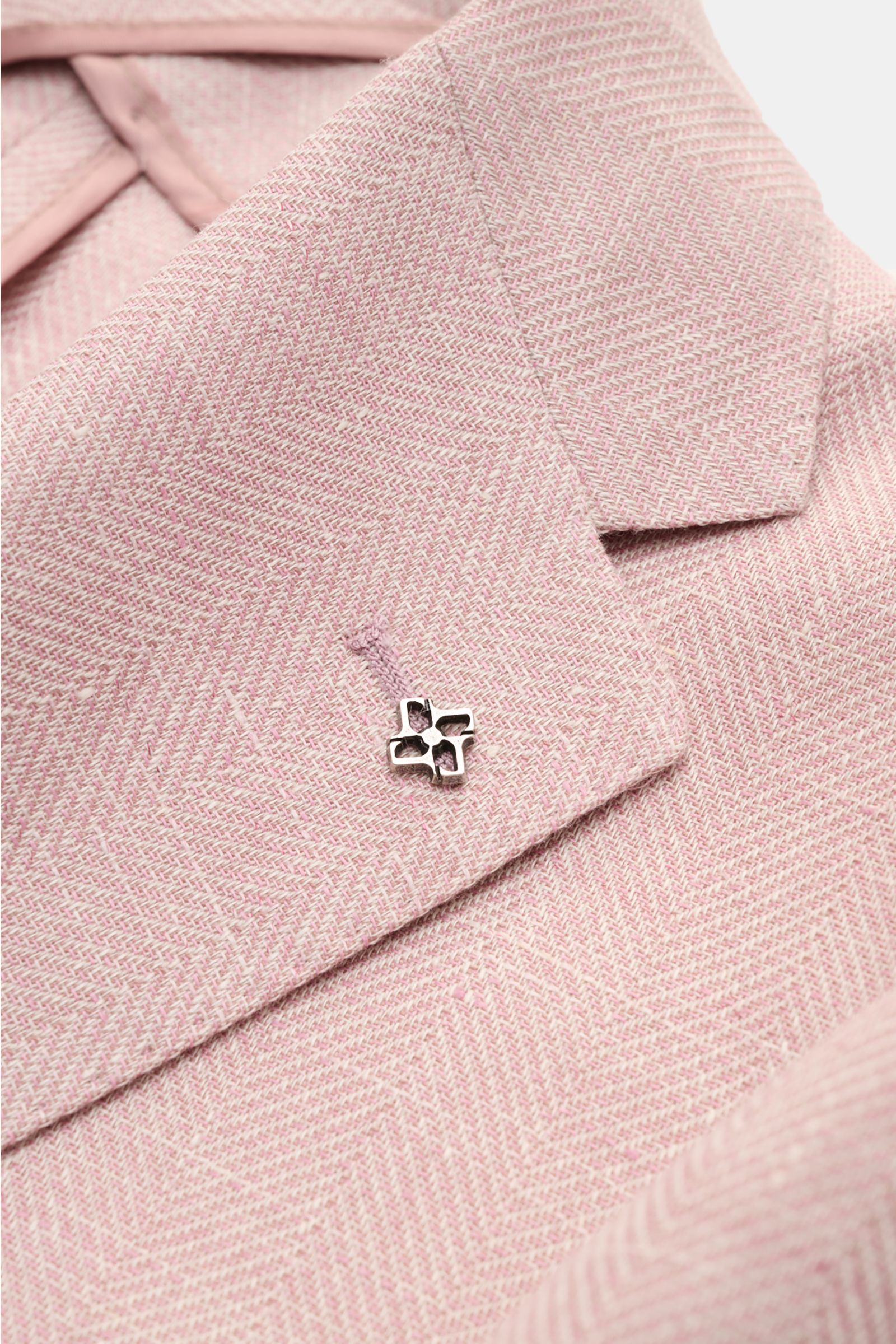 Tagliatore Sakko 'Monte Carlo' altrosa meliert, Nahaufnahme von schräg oben auf das fallende Revers mit markantem Fischgrat-Muster und silbernem Pin.